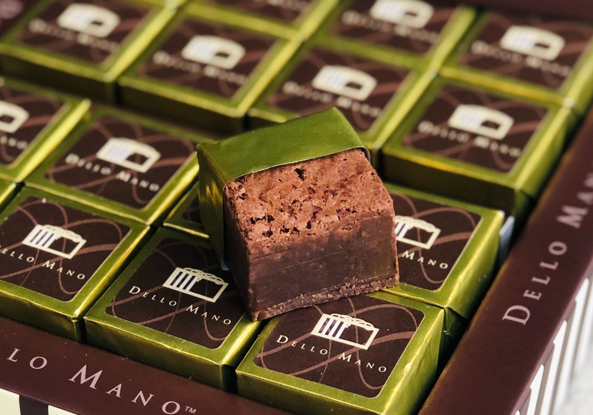 "Dello Mano handmade luxury brownies in signature gold and brown wrappers – crafted in small batches with Belgian chocolate, delivered Australia-wide for gifting and celebrations.