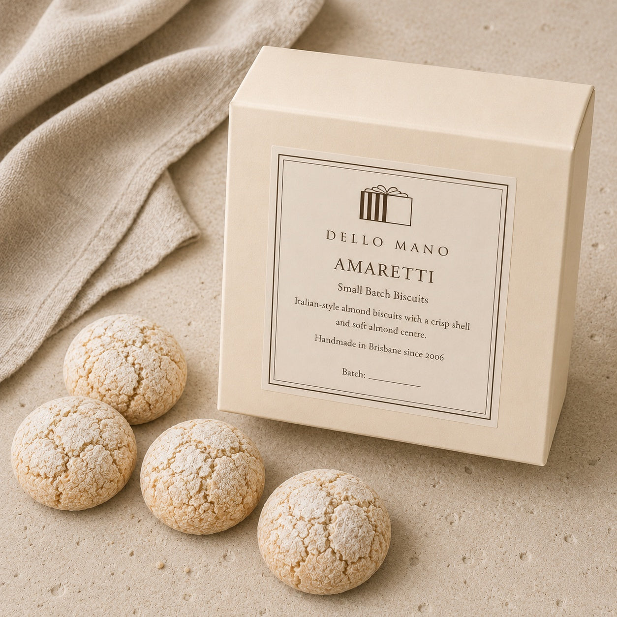 Dello Mano Amaretti gift box with handmade Italian-style almond biscuits on a natural linen background