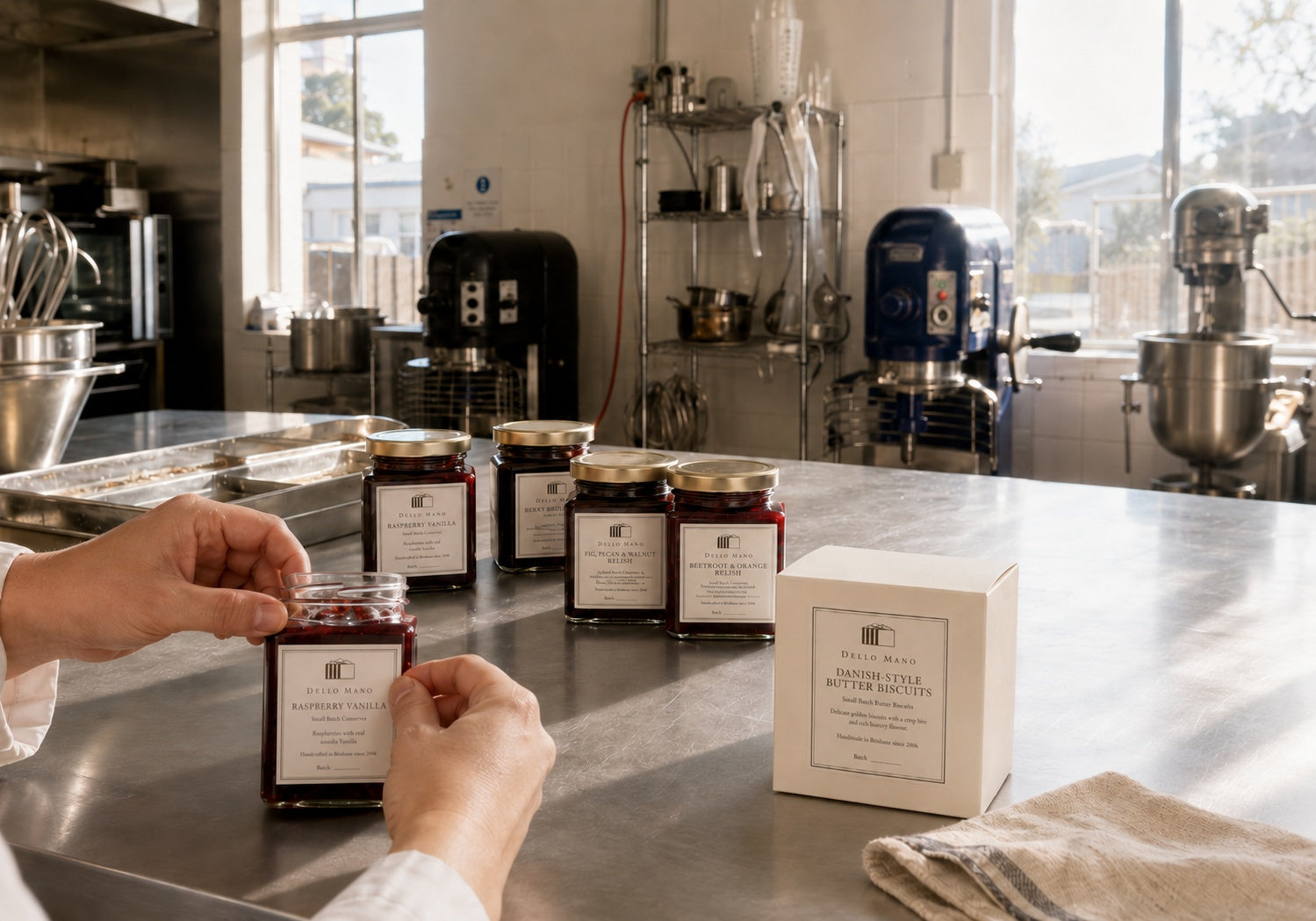 Dello Mano preserves being labelled by hand beside Danish-style butter biscuits in our West End Brisbane kitchen.