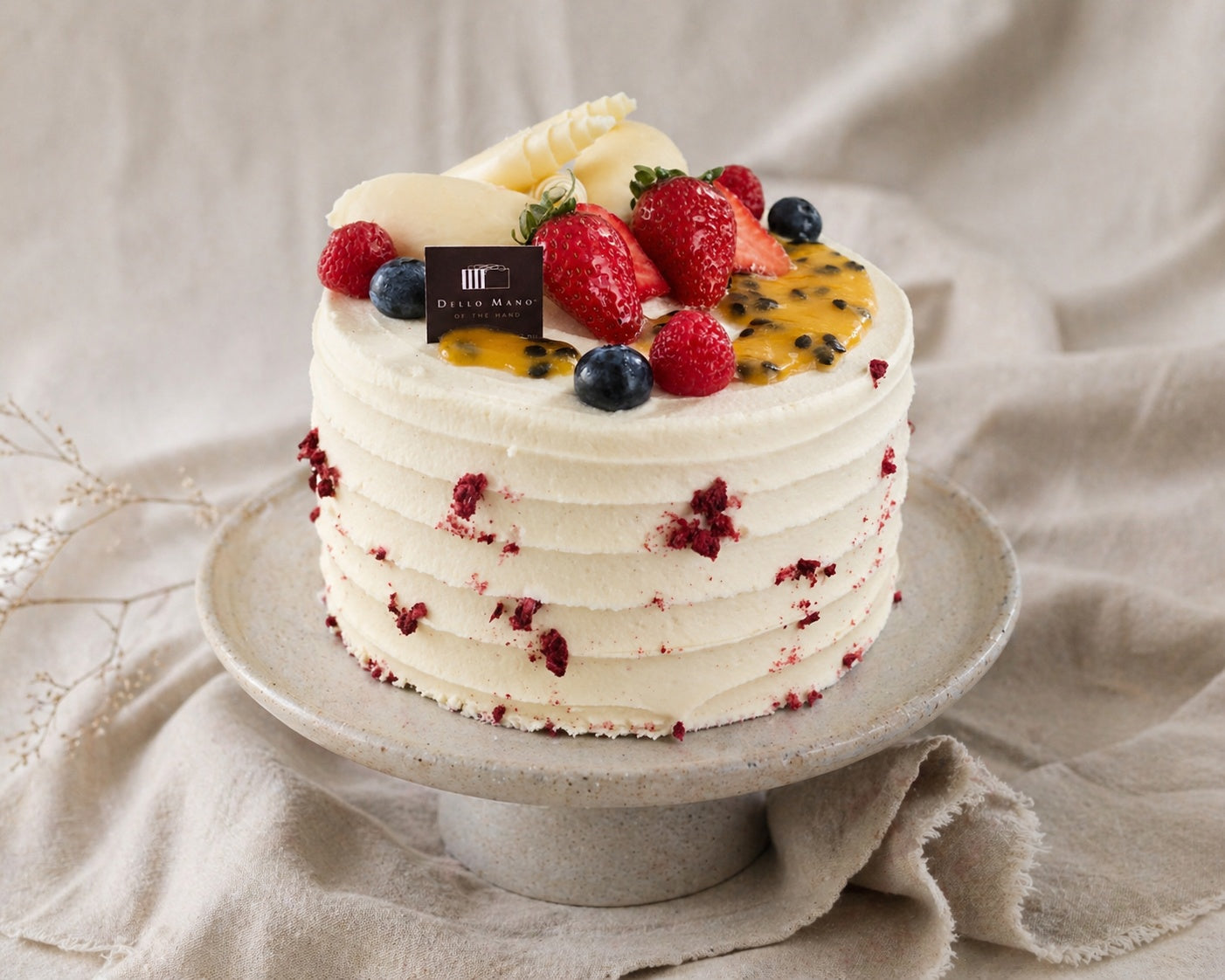 handmade cake Brisbane on ceramic stand styled with soft linen background in natural light