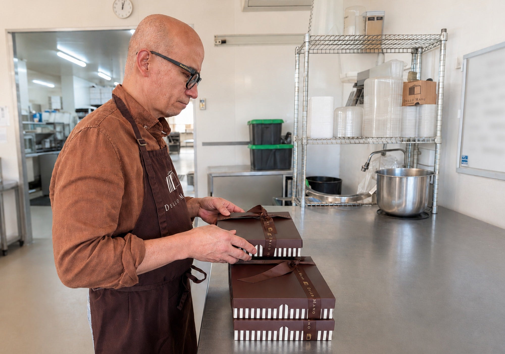 Dello Mano co-founder Bien checking handmade brownie gift boxes in the Brisbane kitchen