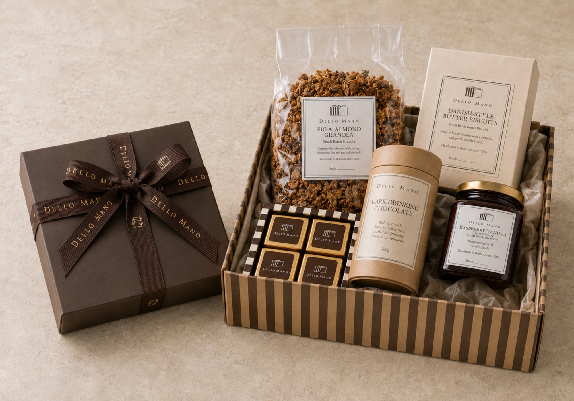 Dello Mano signature brownie gift box beside an open striped corporate hamper filled with brownies, biscuits, granola, preserve and drinking chocolate.