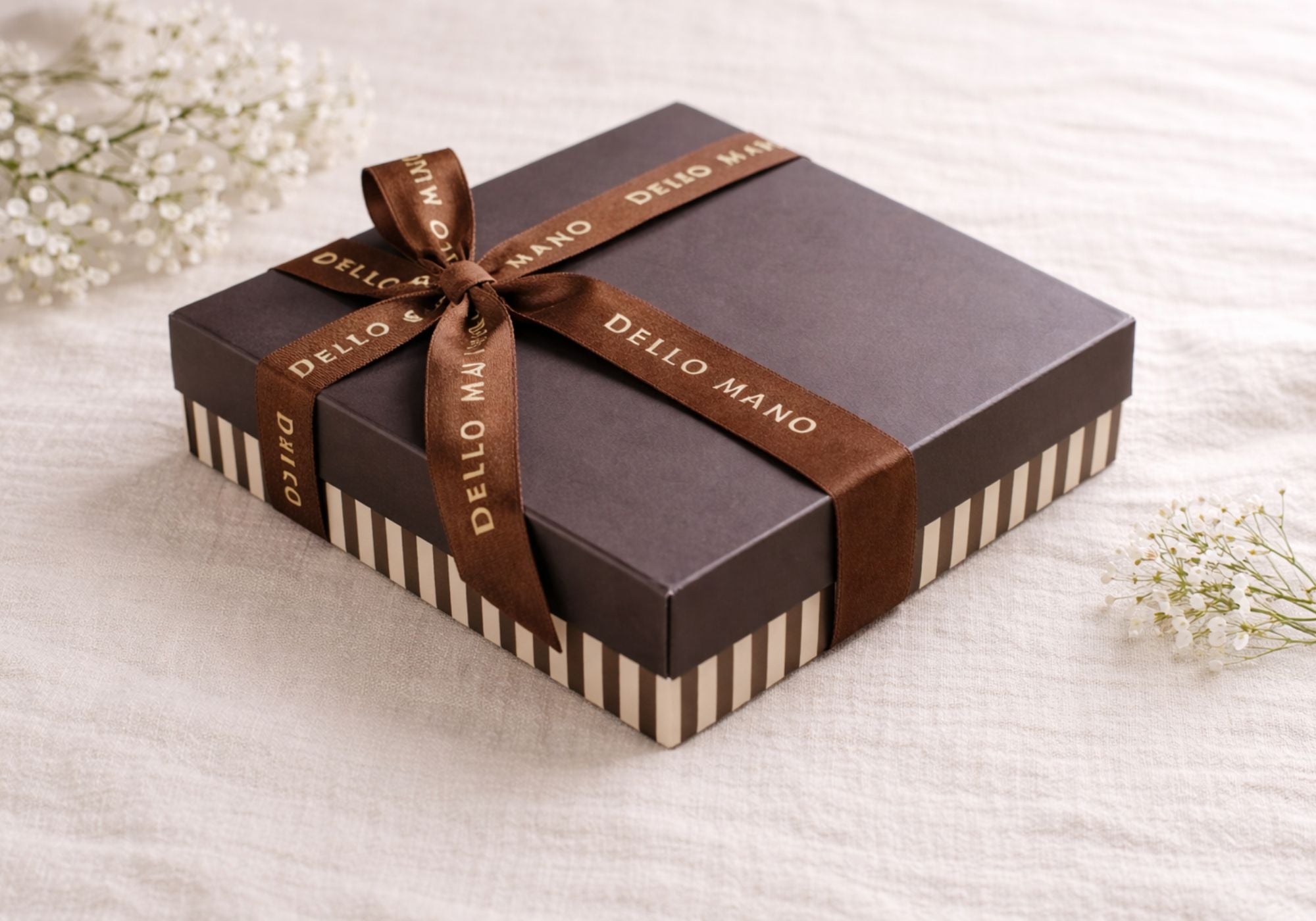 Handmade Dello Mano chocolate gift box wrapped in ribbon on linen background, luxury chocolate gift box for delivery across Australia.