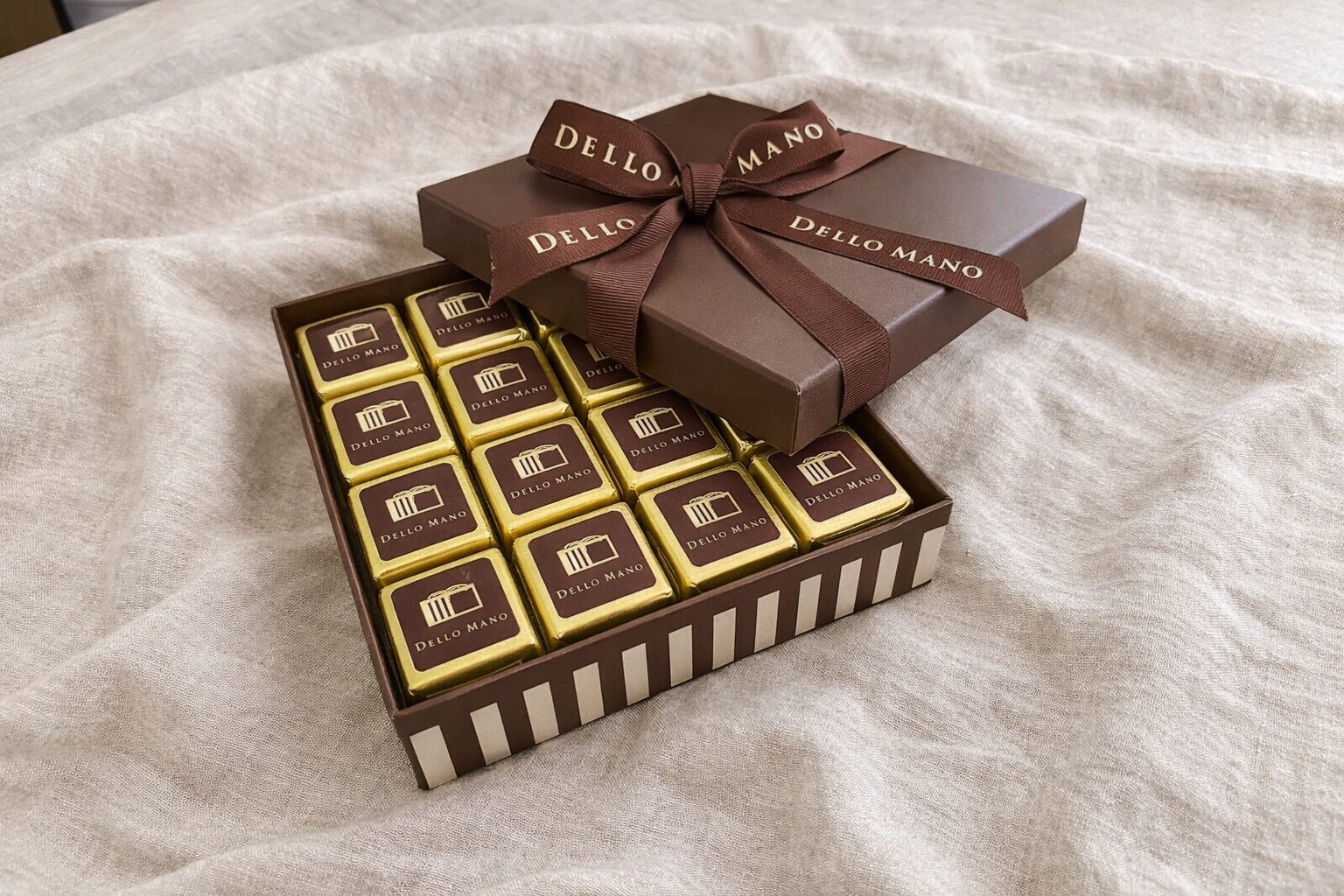 Open Dello Mano chocolate gift box with sixteen square handmade brownies on calm linen background for chocolate gift delivery Brisbane