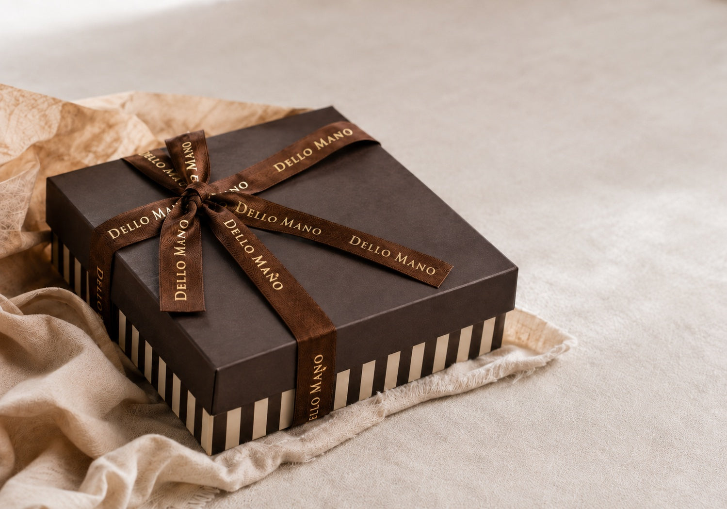 Dello Mano chocolate gift box with gold-embossed brown ribbon and striped base, prepared for delivery throughout Australia.