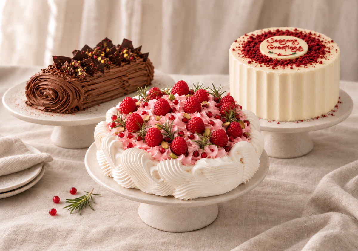 Handmade Dello Mano raspberry pavlova, chocolate Christmas log and Red Velvet Christmas cake on cream stands.