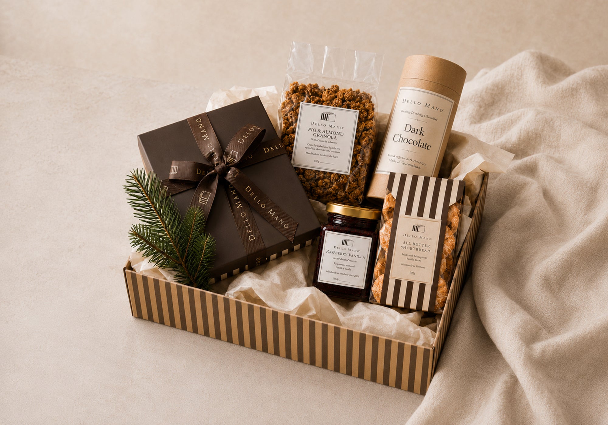 Dello Mano corporate Christmas hamper with handmade food arranged in a recyclable striped kraft gift box.