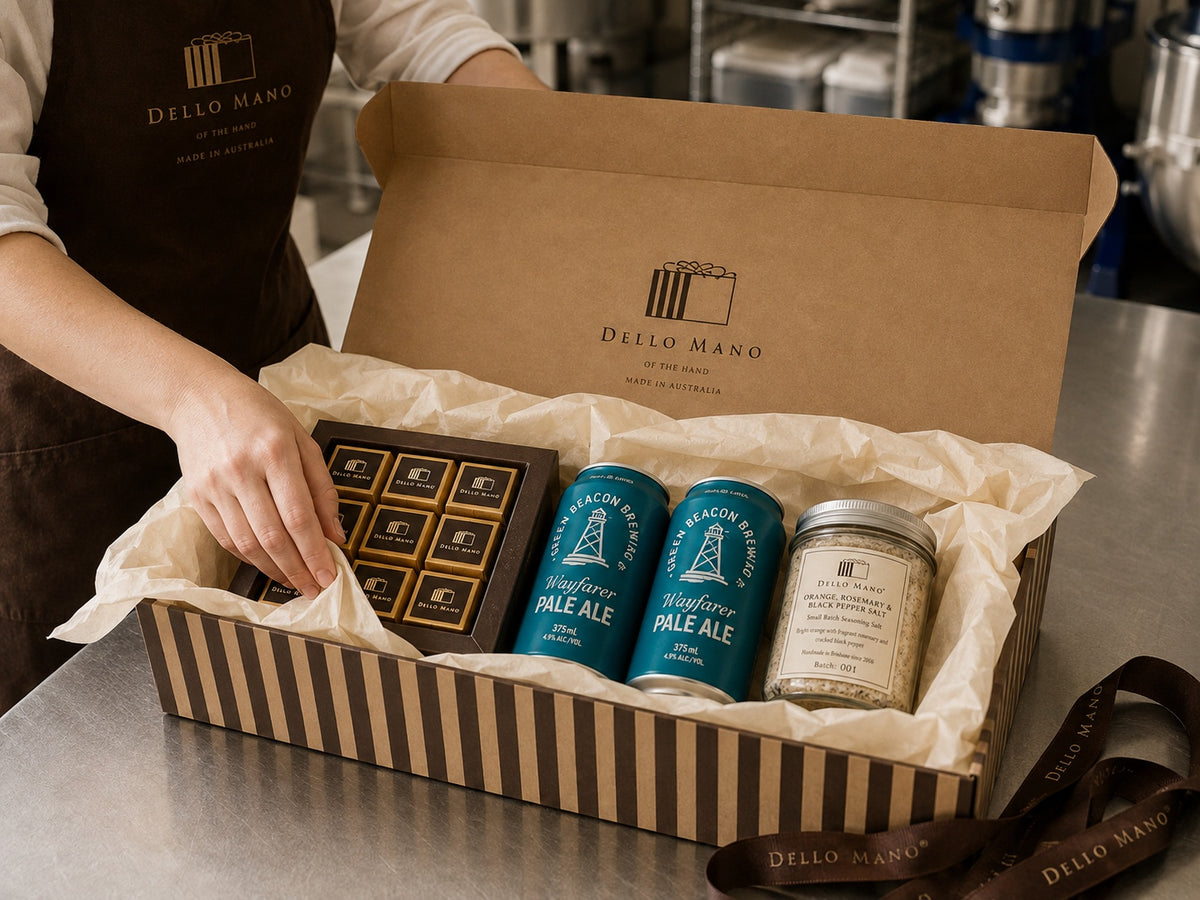 Dello Mano Father’s Day hamper being packed in the Brisbane kitchen with brownie gift box, Green Beacon pale ale, Orange Rosemary & Black Pepper Salt and cream tissue paper.