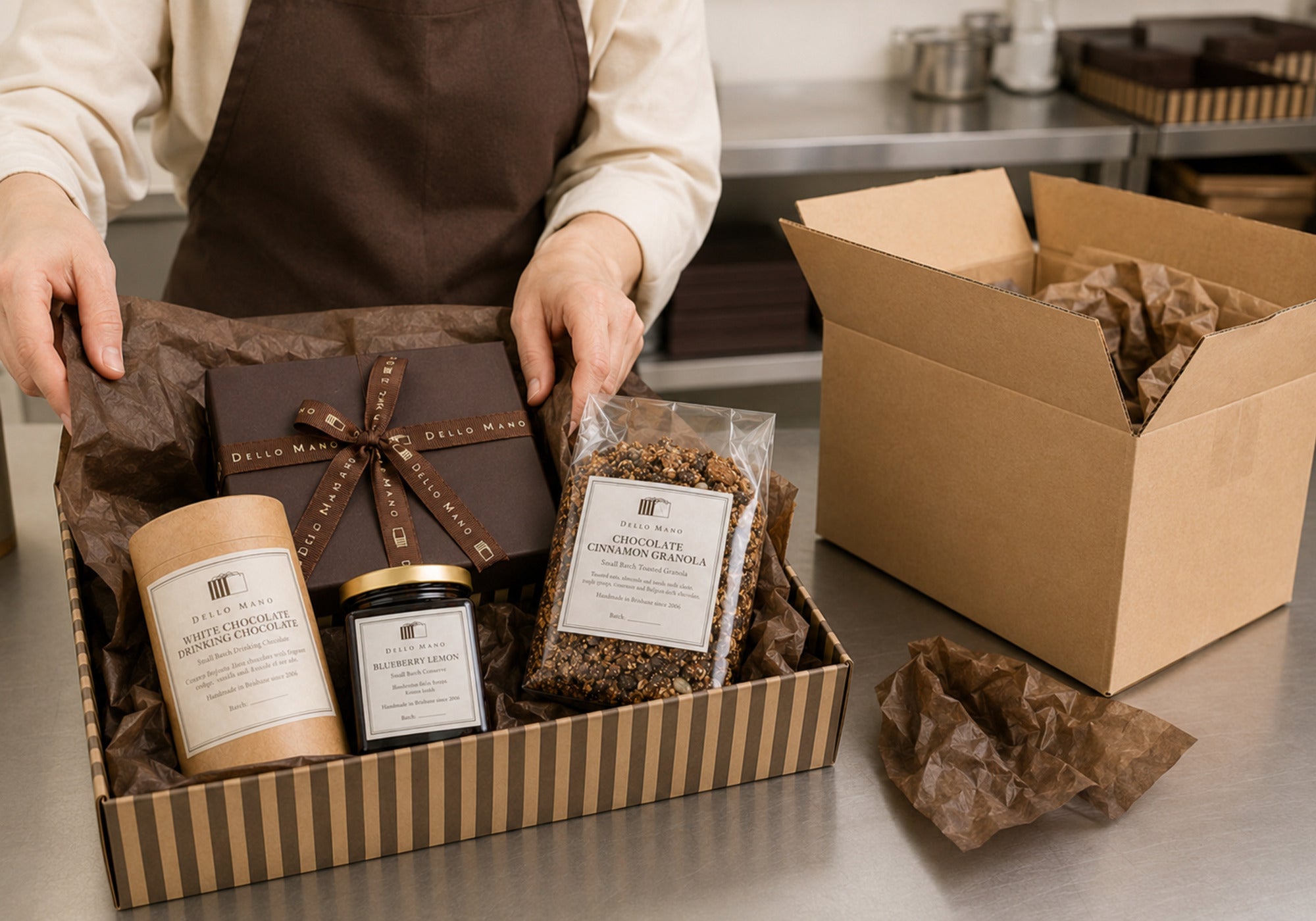 Dello Mano team member in a brown apron carefully packing a handmade hamper with protective tissue for Australia-wide delivery.