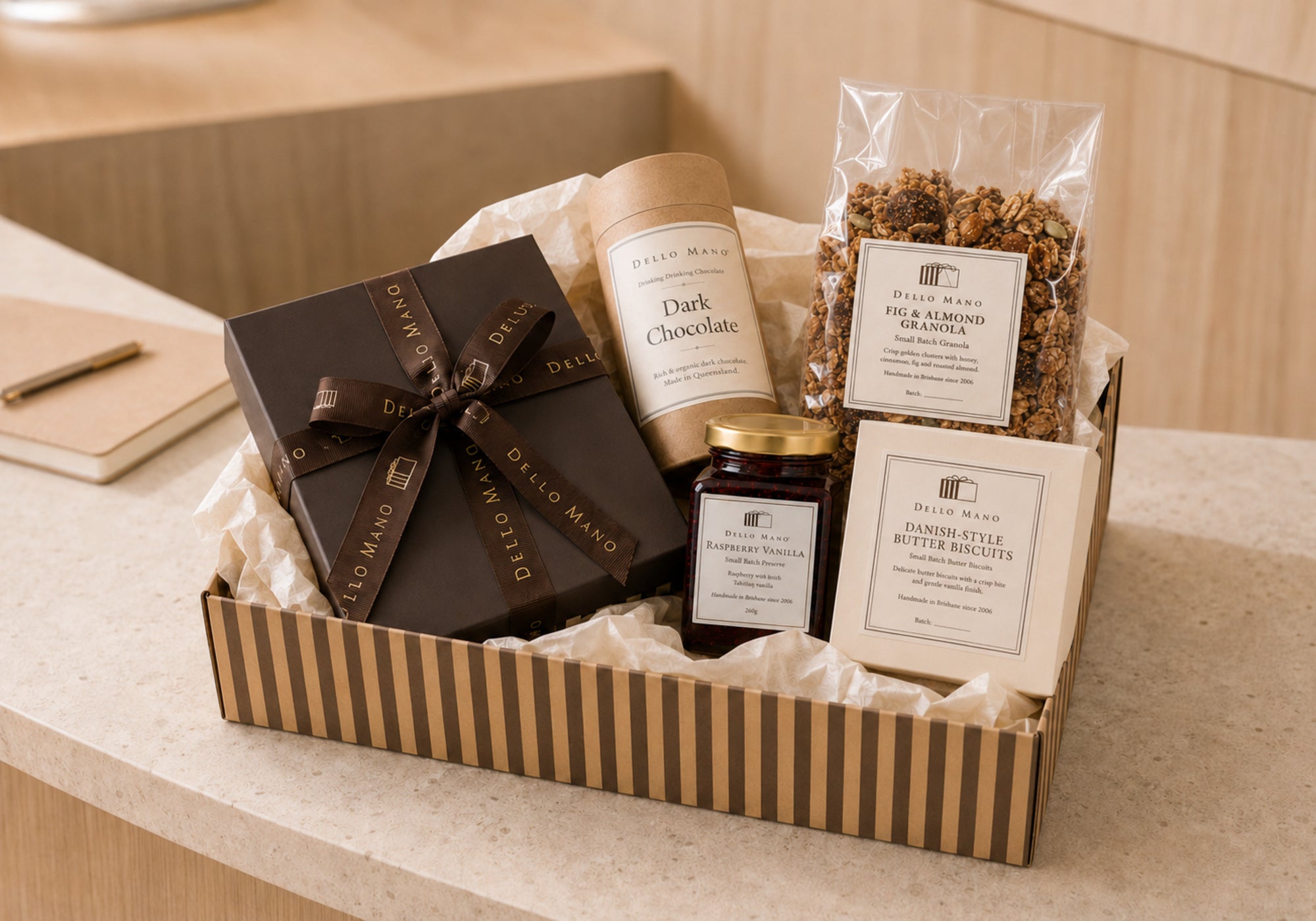 Open Dello Mano corporate hamper with handmade brownies, drinking chocolate, raspberry vanilla preserve, fig and almond granola and Danish-style butter biscuits.