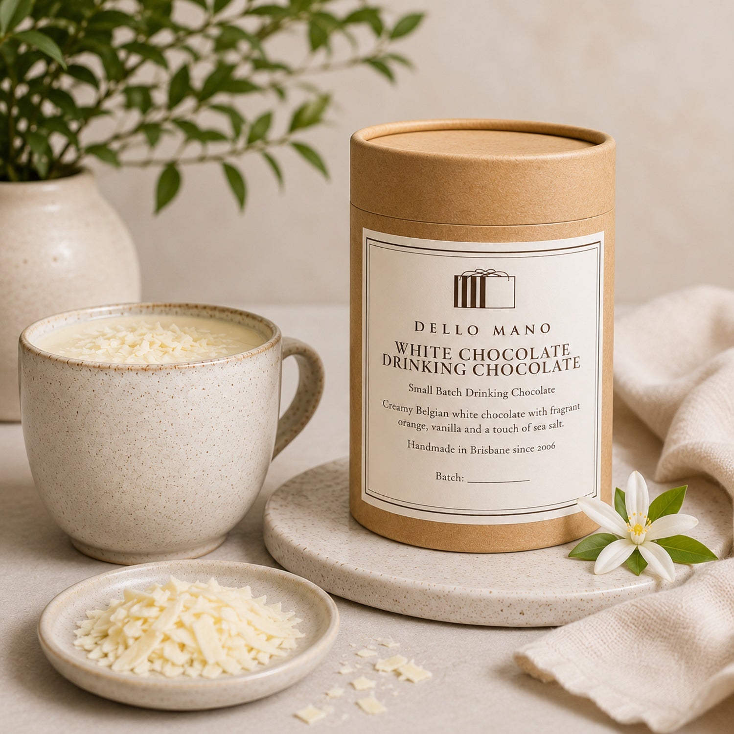 Dello Mano White Chocolate Drinking Chocolate made with Belgian white chocolate, orange, vanilla and sea salt, served beside the 180 g canister.