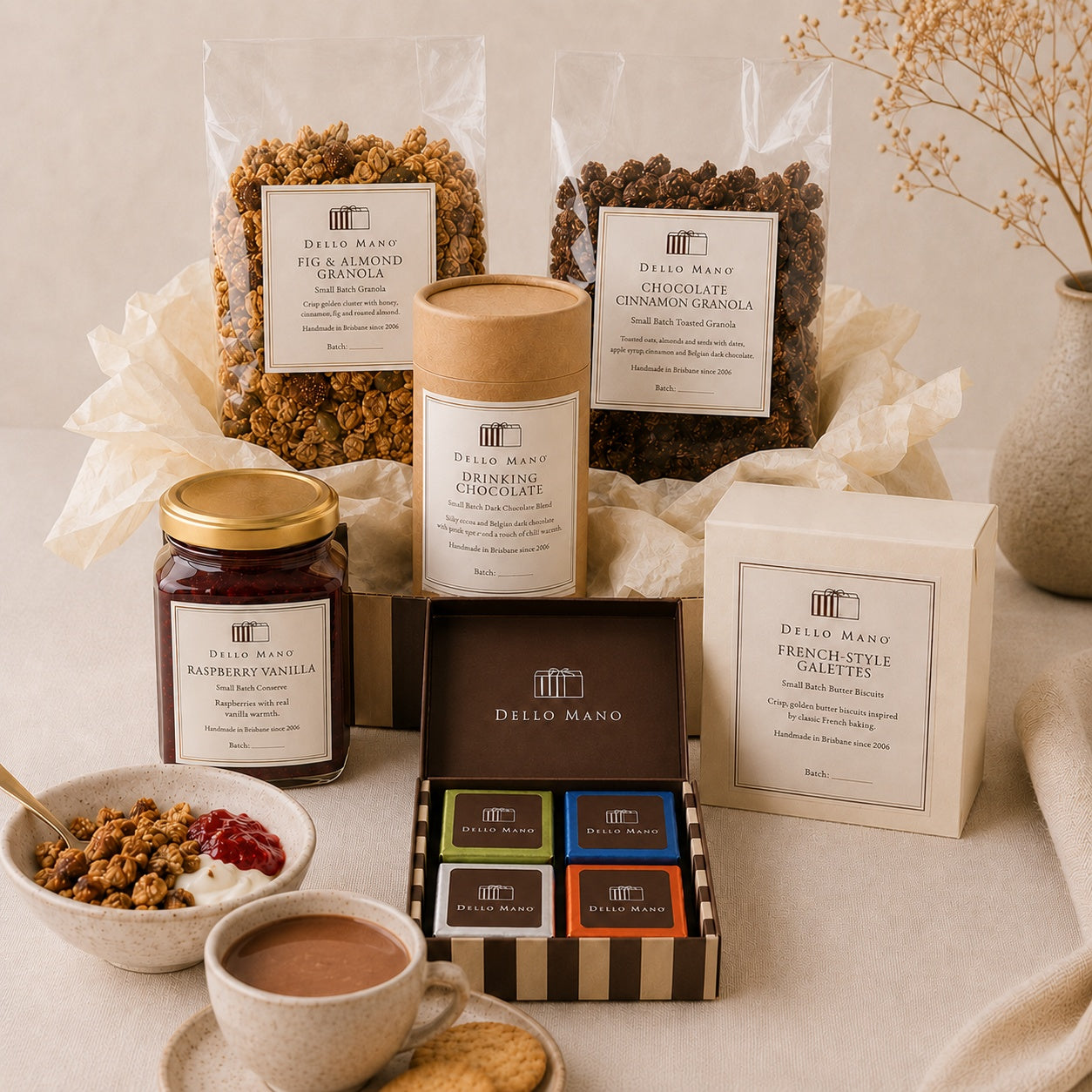 Dello Mano Slow Morning Hamper with Fig & Almond Granola, Chocolate Cinnamon Granola, Raspberry Vanilla Jam, French-Style Galettes, drinking chocolate and a four-piece mixed brownie gift box.