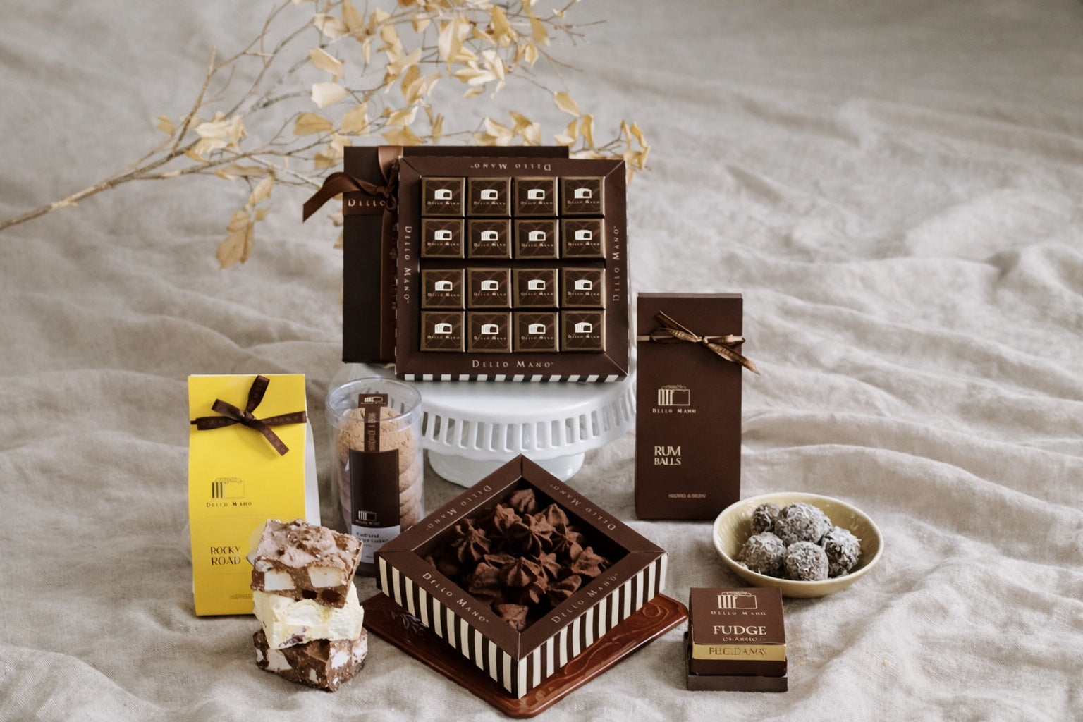 Handmade chocolate gift selection with brownies, hampers and artisan treats on soft linen background