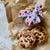 Chocolate Chip Cookies with a stack behind wrapped with white ribbon with red hearts. The cookies are on crumbled brown paper