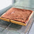 A caramel chocolate custard tart on a cooling rack
