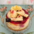 White Chocolate Raspberry Cheesecake with white chocolate decorations, and tag that says Dello Mano