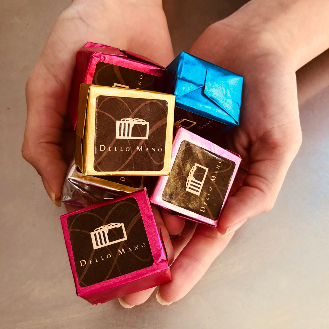 A hand holding a variety of Dello Mano Luxury Brownies