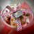 A clear showcase box of gingerbread heart cookies with Valentines Day ribbon and a brown tag with Dello Mano logo