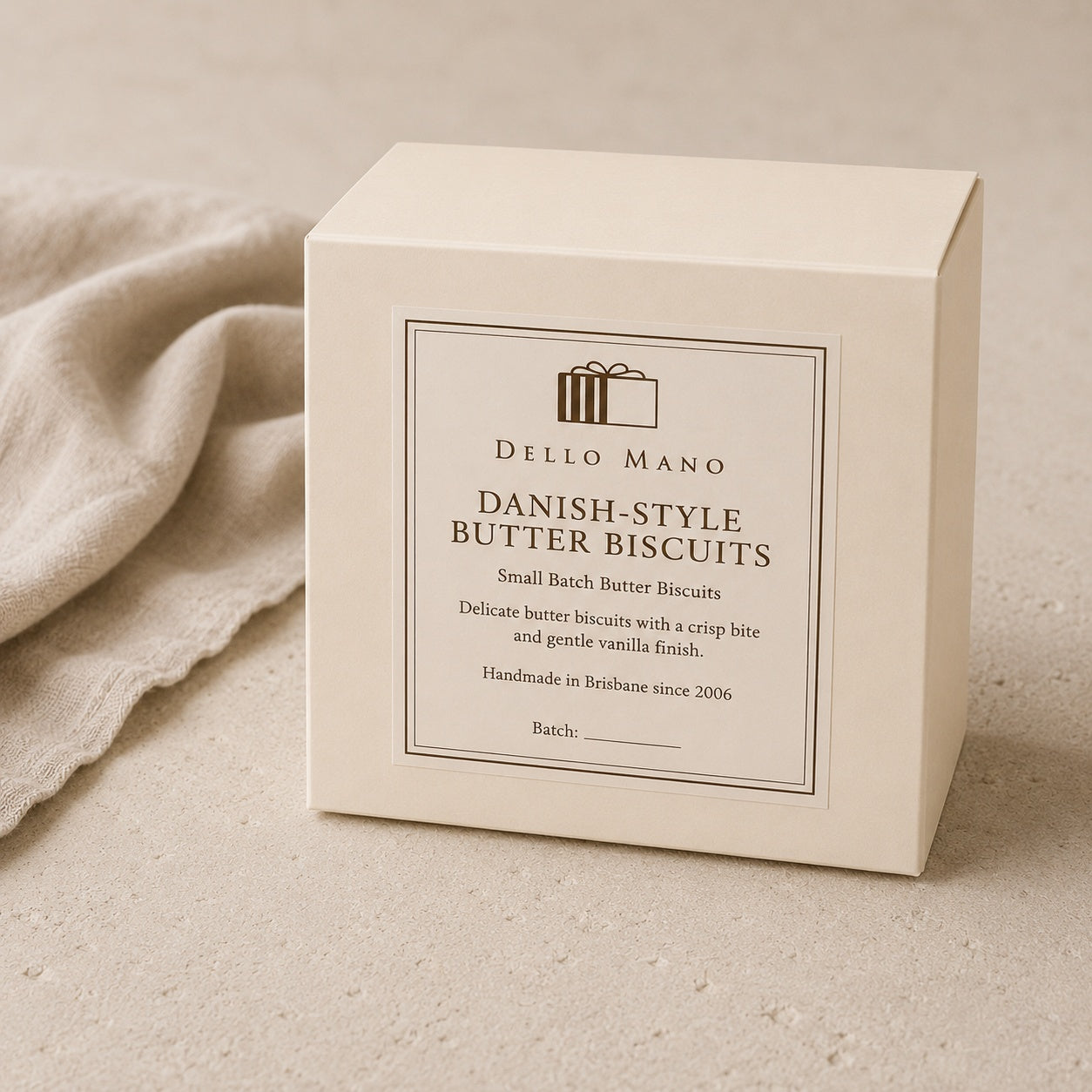 Dello Mano Danish-Style Butter Biscuits gift box in elegant warm cream packaging on a natural linen background