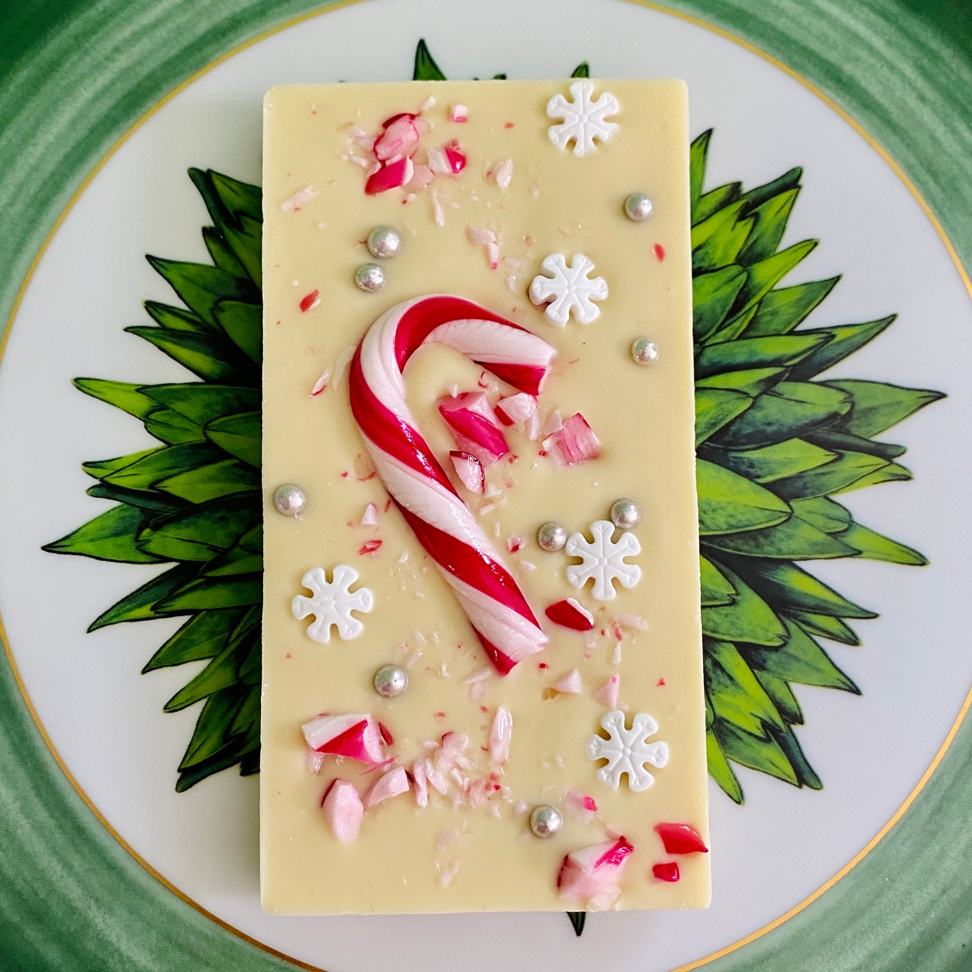Snowy Peppermint Bliss - A single 110g white Belgian chocolate bar adorned with candy canes, silver sugar balls, and snowflakes