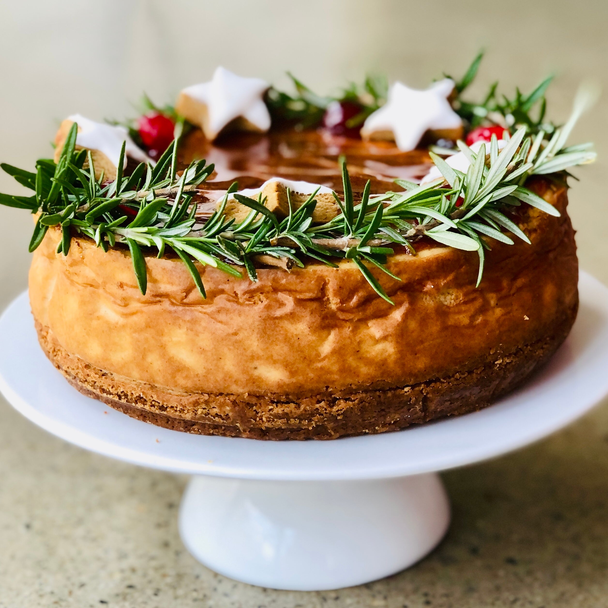 Generous Gingerbread Base of Starstruck Gingerbread Cheesecake on a white cake stand