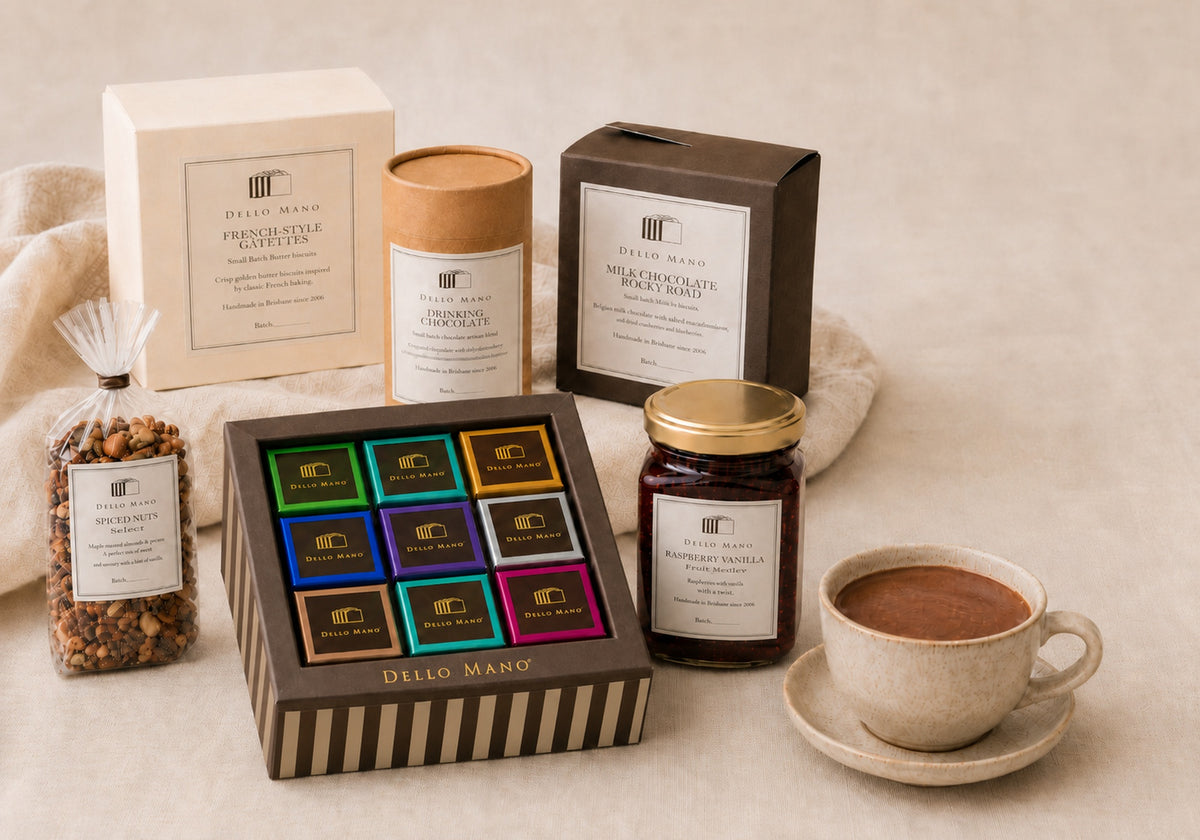 The Dello Mano Signature Hamper contents with a 9-piece mixed brownie gift box, French-style galettes, drinking chocolate, Rocky Road, spiced nuts, Raspberry Vanilla Jam and a cup of drinking chocolate.
