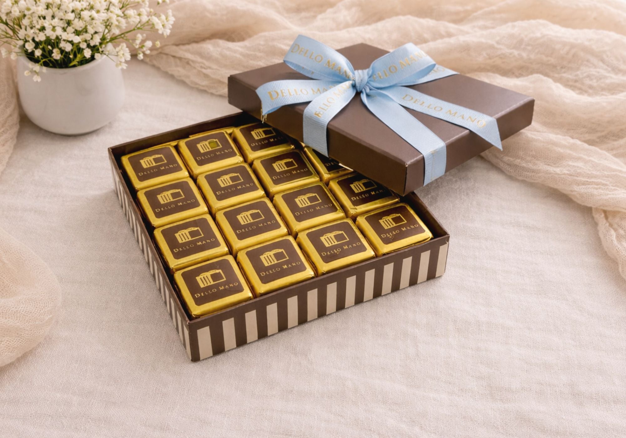 Open Dello Mano chocolate gift box with gold-wrapped brownie squares on soft linen background, luxury chocolate gift box Australia