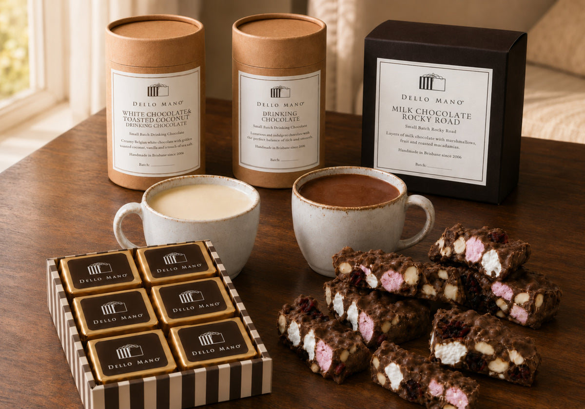 Dello Mano White Chocolate and Toasted Coconut Drinking Chocolate, Dark Drinking Chocolate, brownies and Milk Chocolate Rocky Road on a timber table