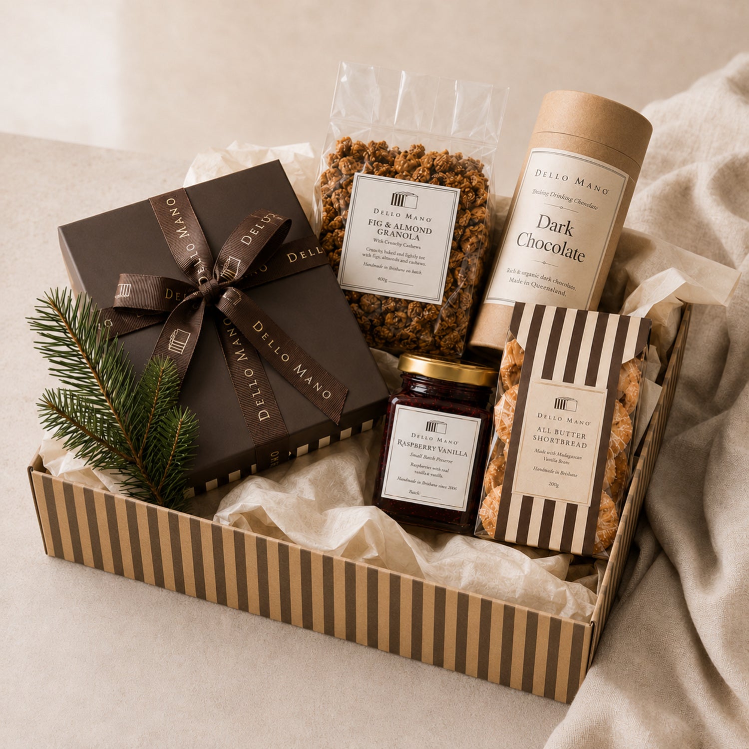 Dello Mano corporate Christmas hamper with handmade food arranged in a recyclable striped kraft gift box.