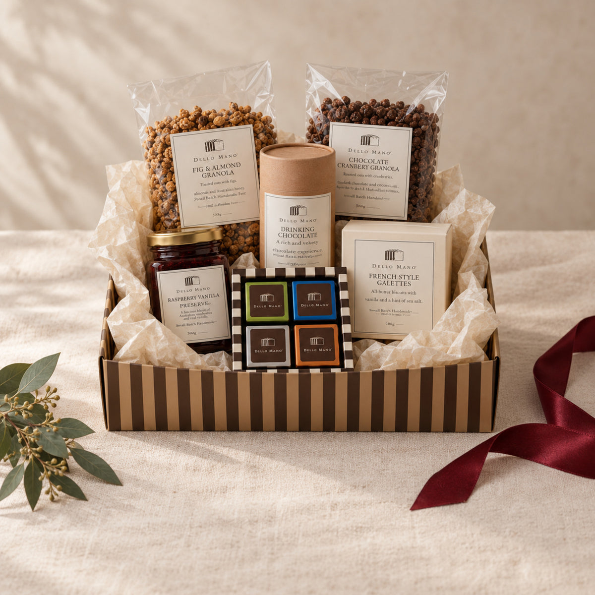Dello Mano Christmas hamper filled with handmade pantry, biscuit and chocolate gifts in a striped presentation box.