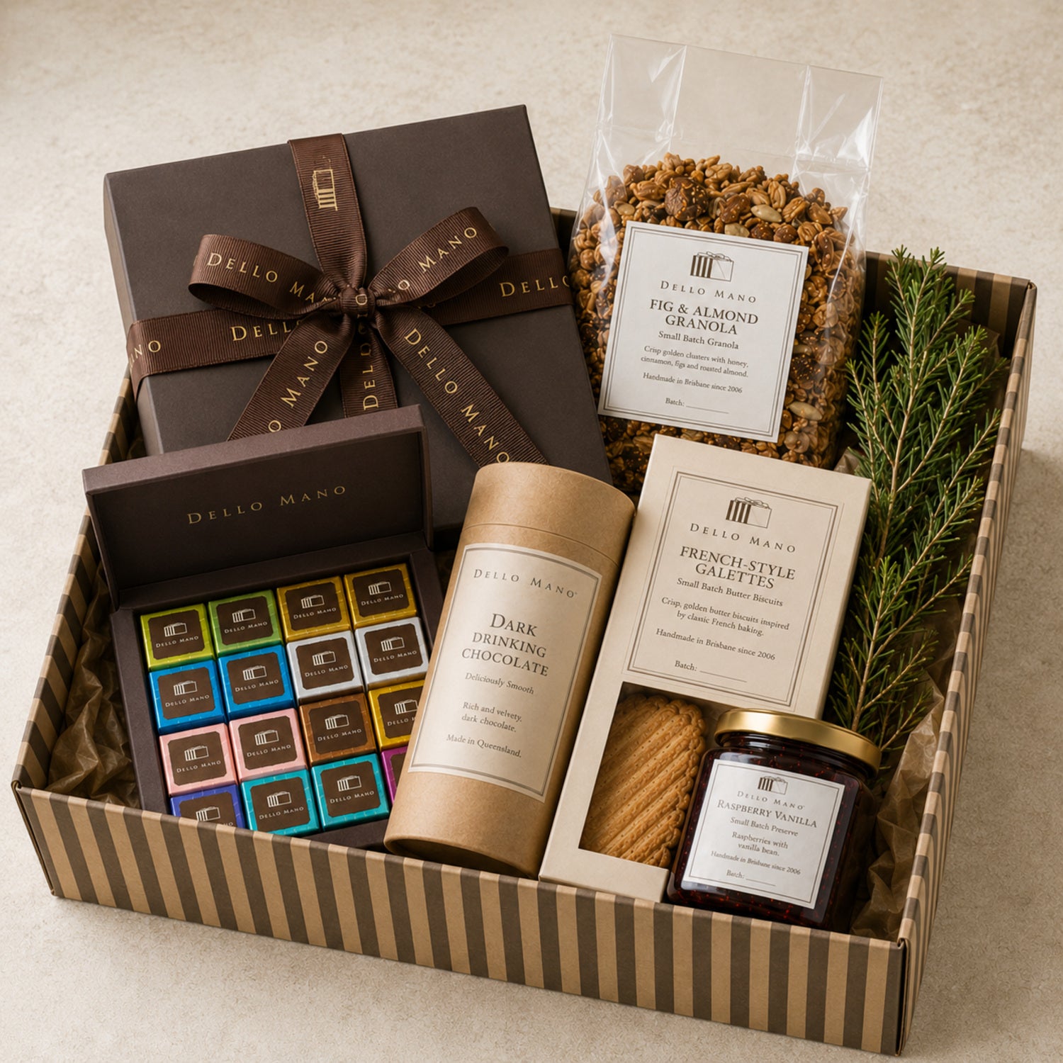 Dello Mano corporate Christmas hamper with handmade brownies, granola, galettes, preserve and drinking chocolate with a restrained natural green sprig.