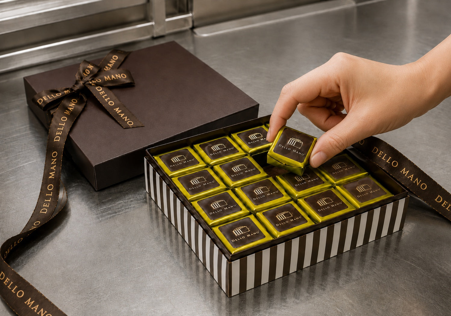Hand placing an individually wrapped Dello Mano brownie into a gift box in the Brisbane kitchen