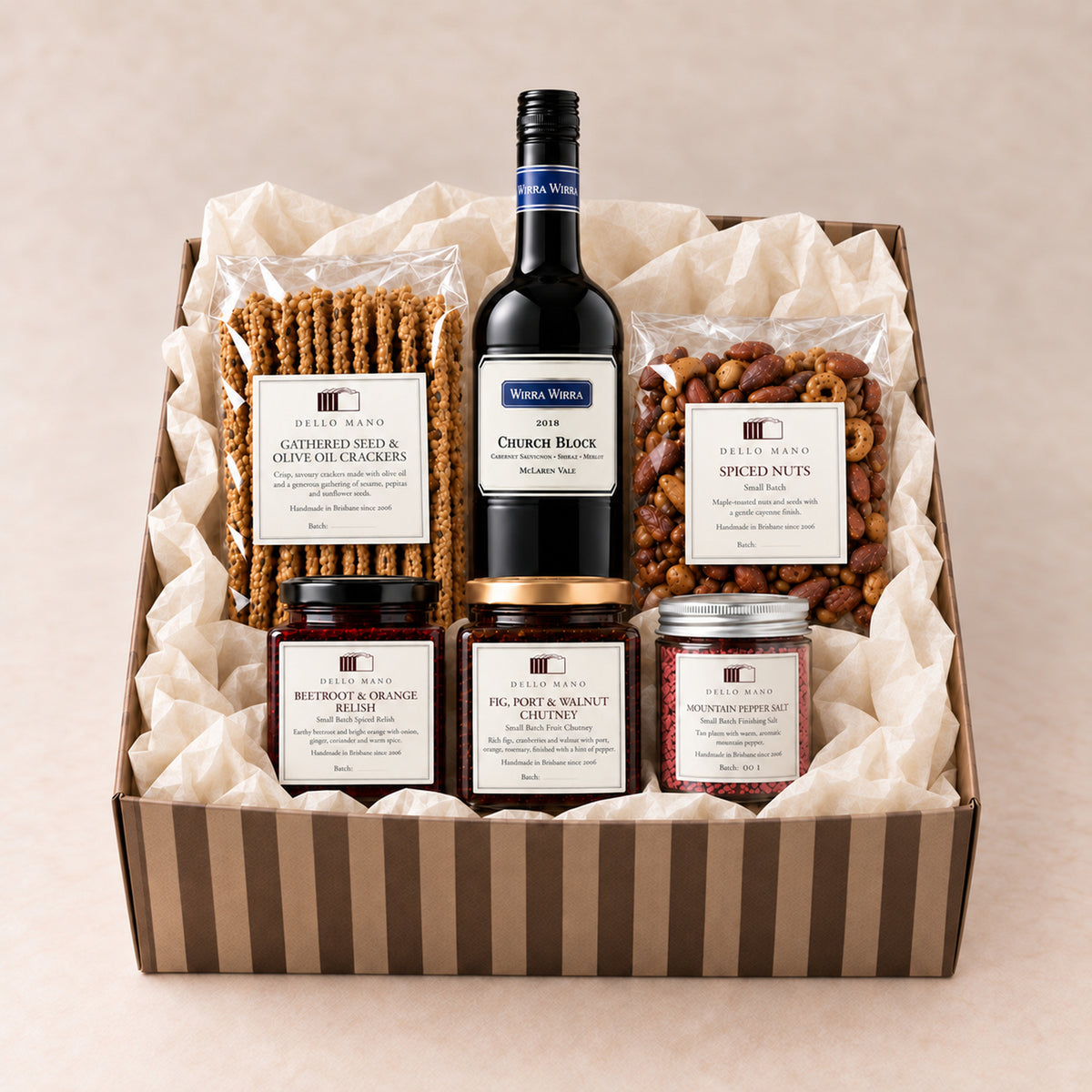 Open striped Dello Mano hamper with 2018 Wirra Wirra Church Block wine, crackers, spiced nuts, beetroot relish, fig chutney and plum pepper salt.