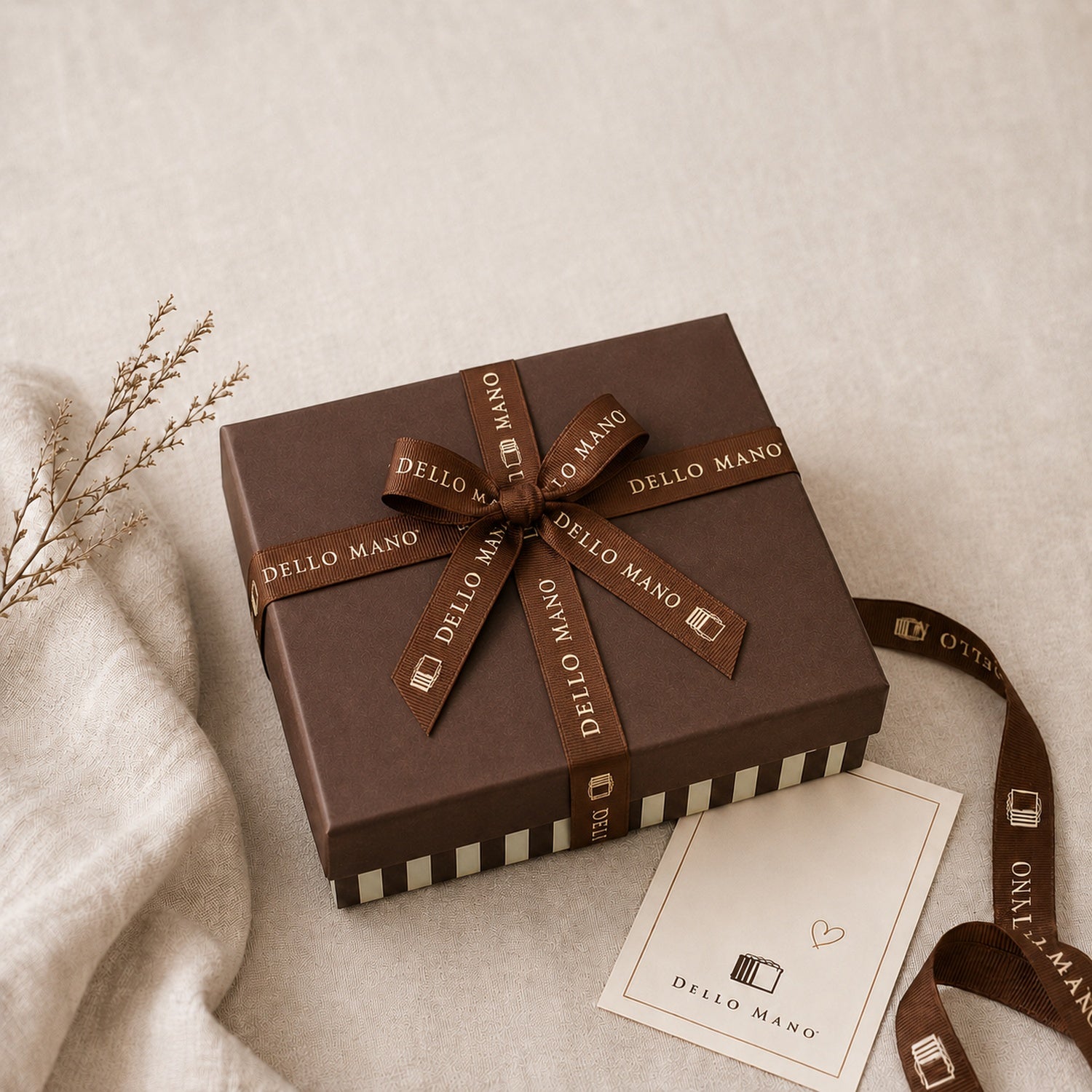 Dello Mano chocolate gift box tied with branded brown ribbon beside a gift card, ready to send across Australia.