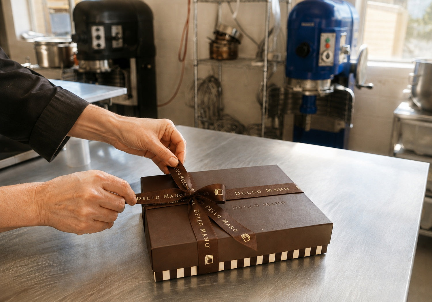 Dello Mano wedding thank-you gift box being hand-finished with ribbon in the Brisbane kitchen