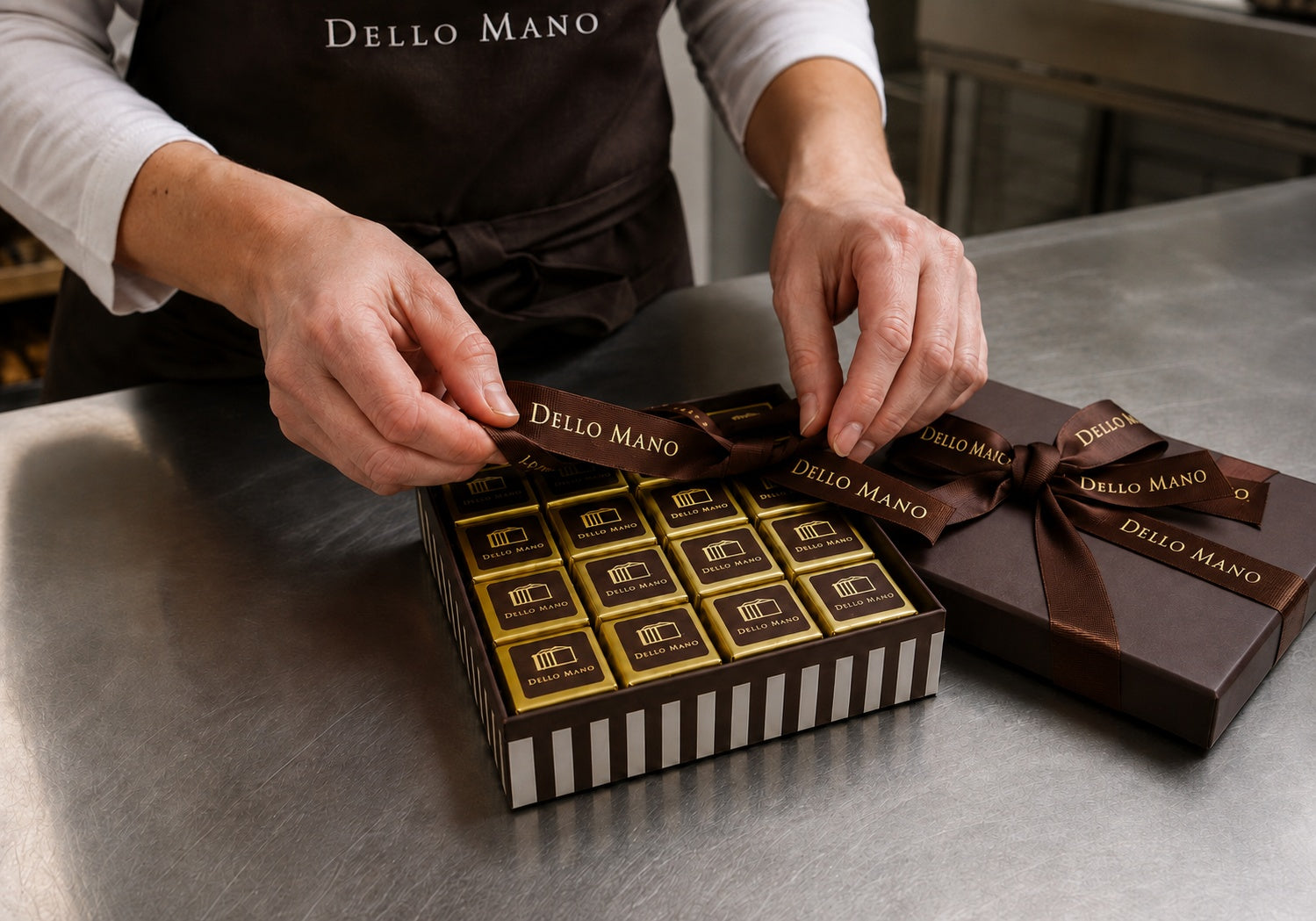Dello Mano corporate chocolate gift box being hand-finished with signature brown ribbon in the Brisbane kitchen.