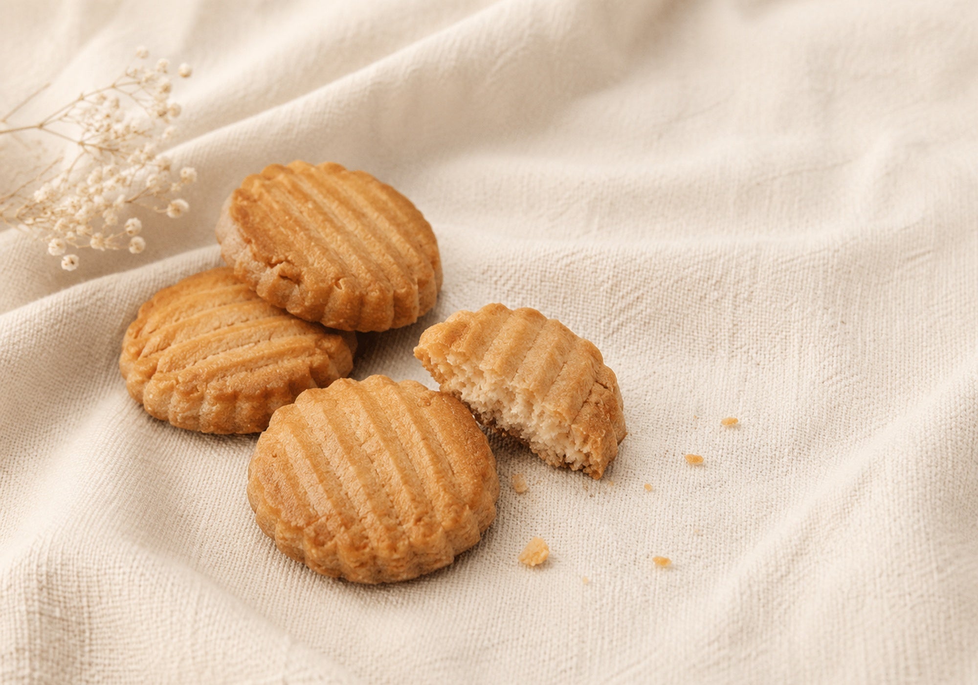 French Galettes arranged on soft cream linen, showing their golden ridged tops and crisp, buttery texture.