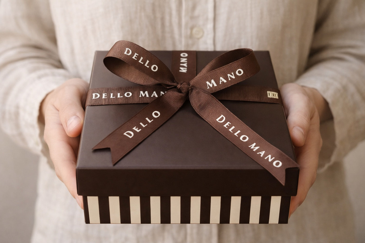 Hand holding a handmade thank you gift box by Dello Mano, beautifully wrapped and ready for gifting