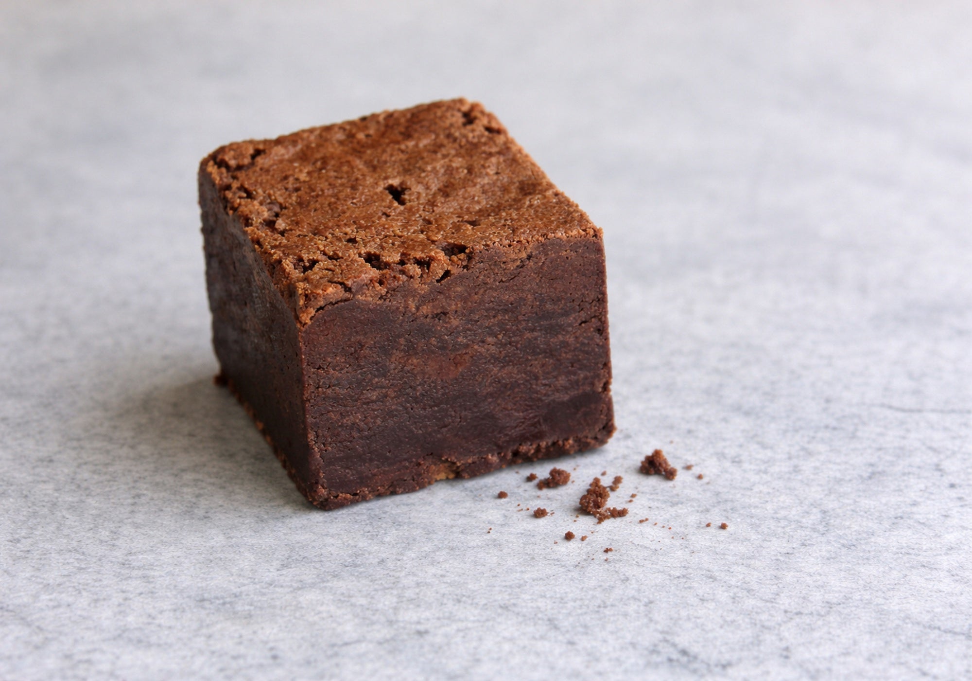 Close-up of handmade brownie showing dense fudgy texture and cube structure