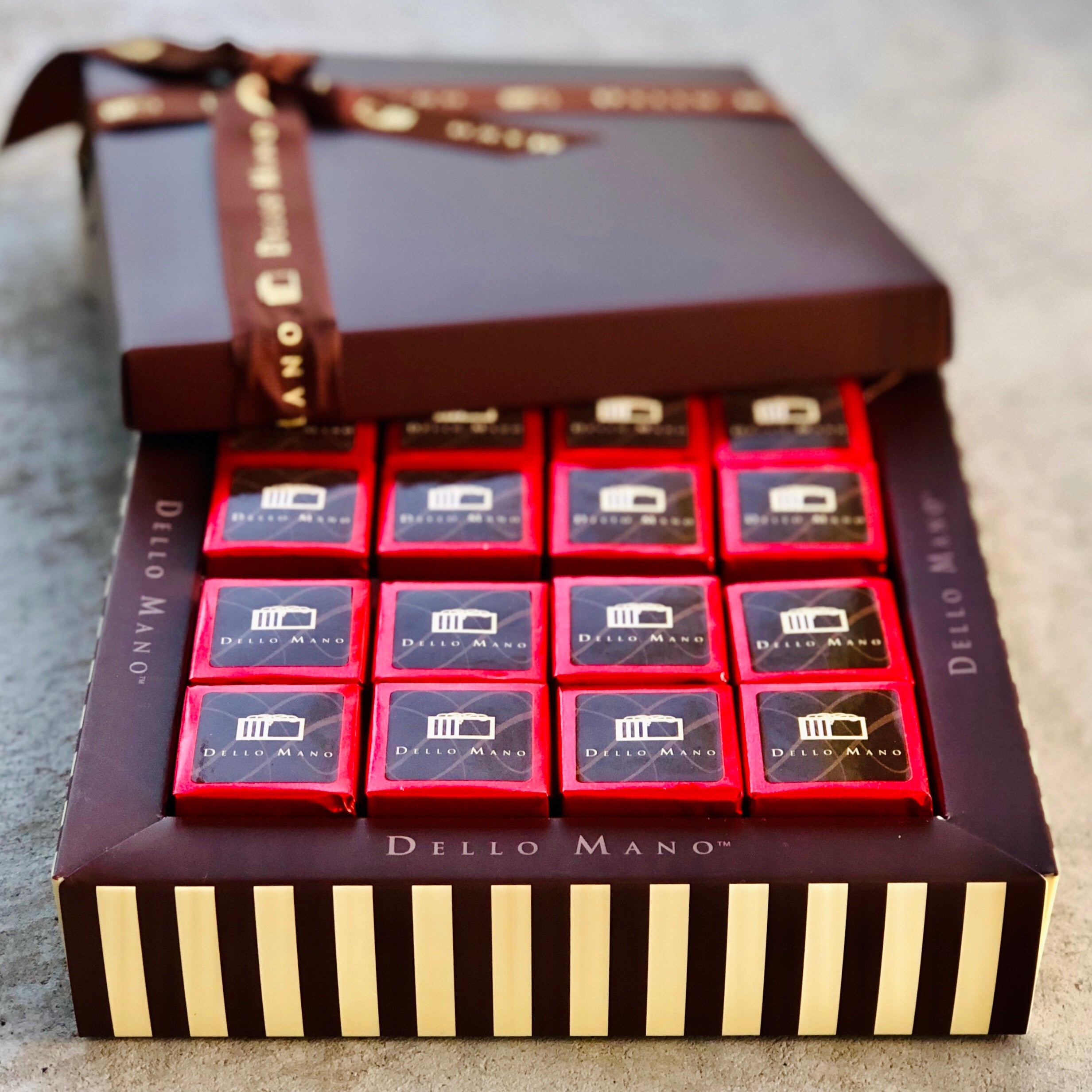 An open gift box of gluten free brownies with lid and premium ribbon