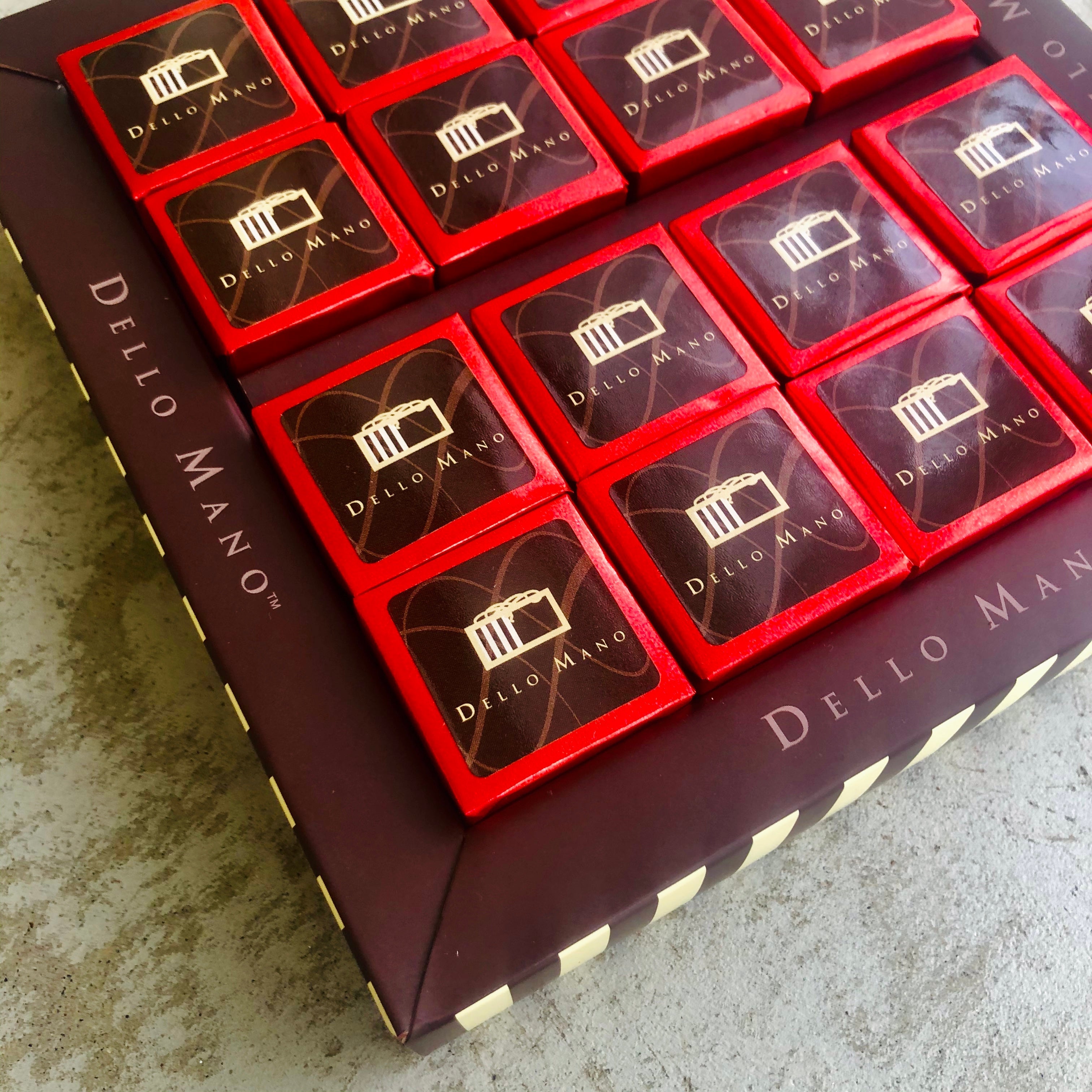 Lines of red foil individually wrapped gluten free brownies in a gift box