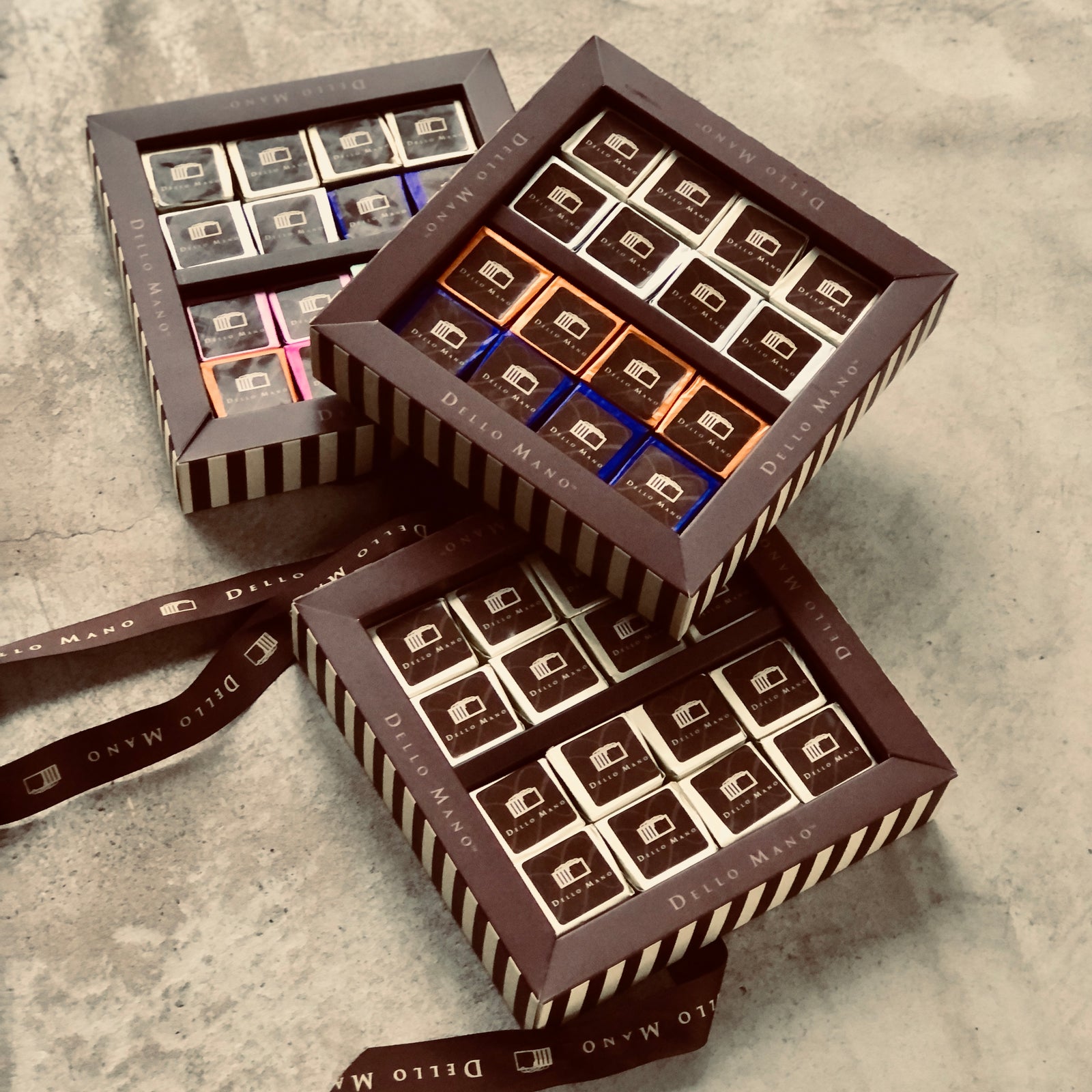 A stack of 3 brownie gift boxes with coloured brownie cubes