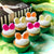 Six Easter Bunny Cupcakes with different coloured ears sitting in front of a cupcake gift box.