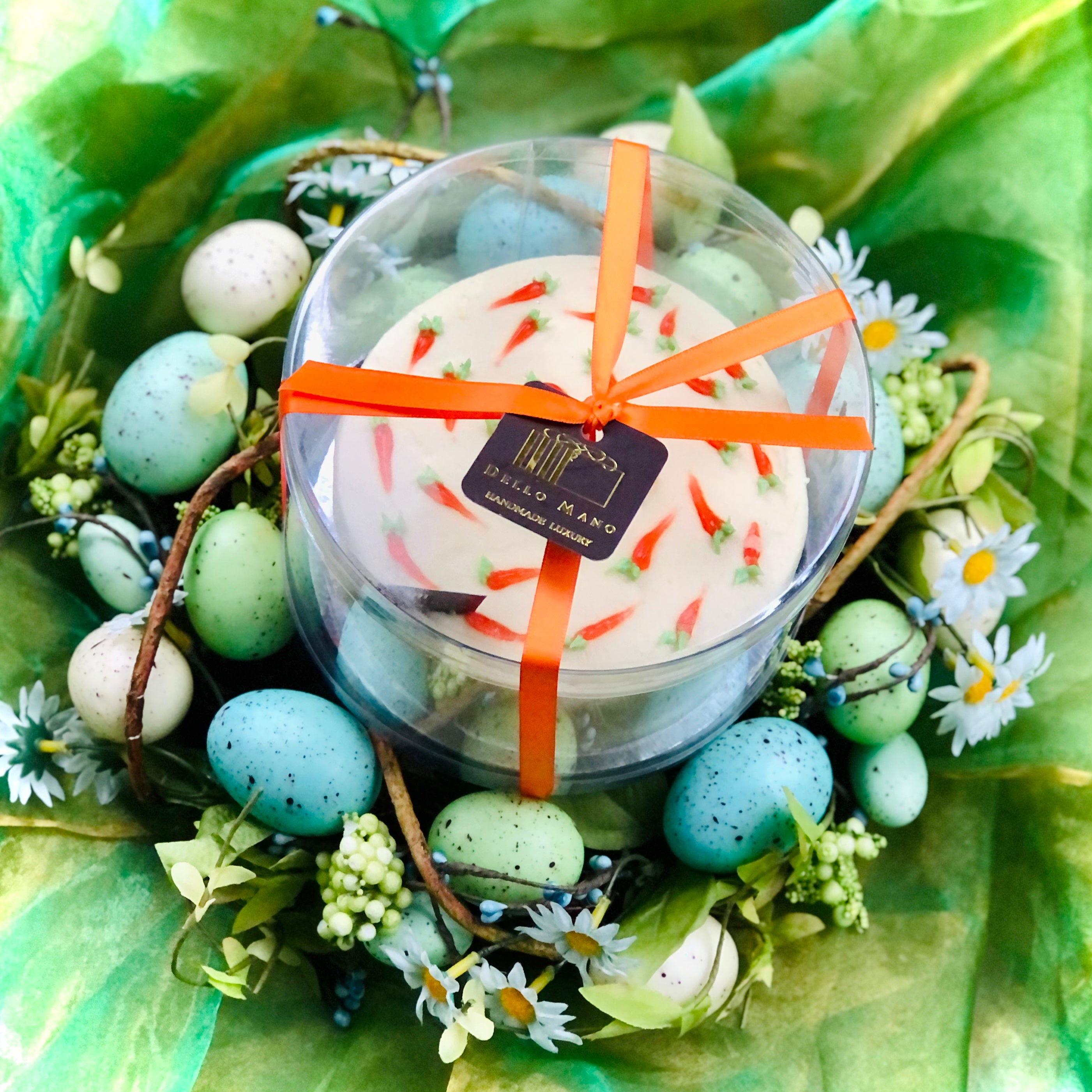 Top view of an Easter Cake gift box with orange ribbon sitting in an Easter wreath