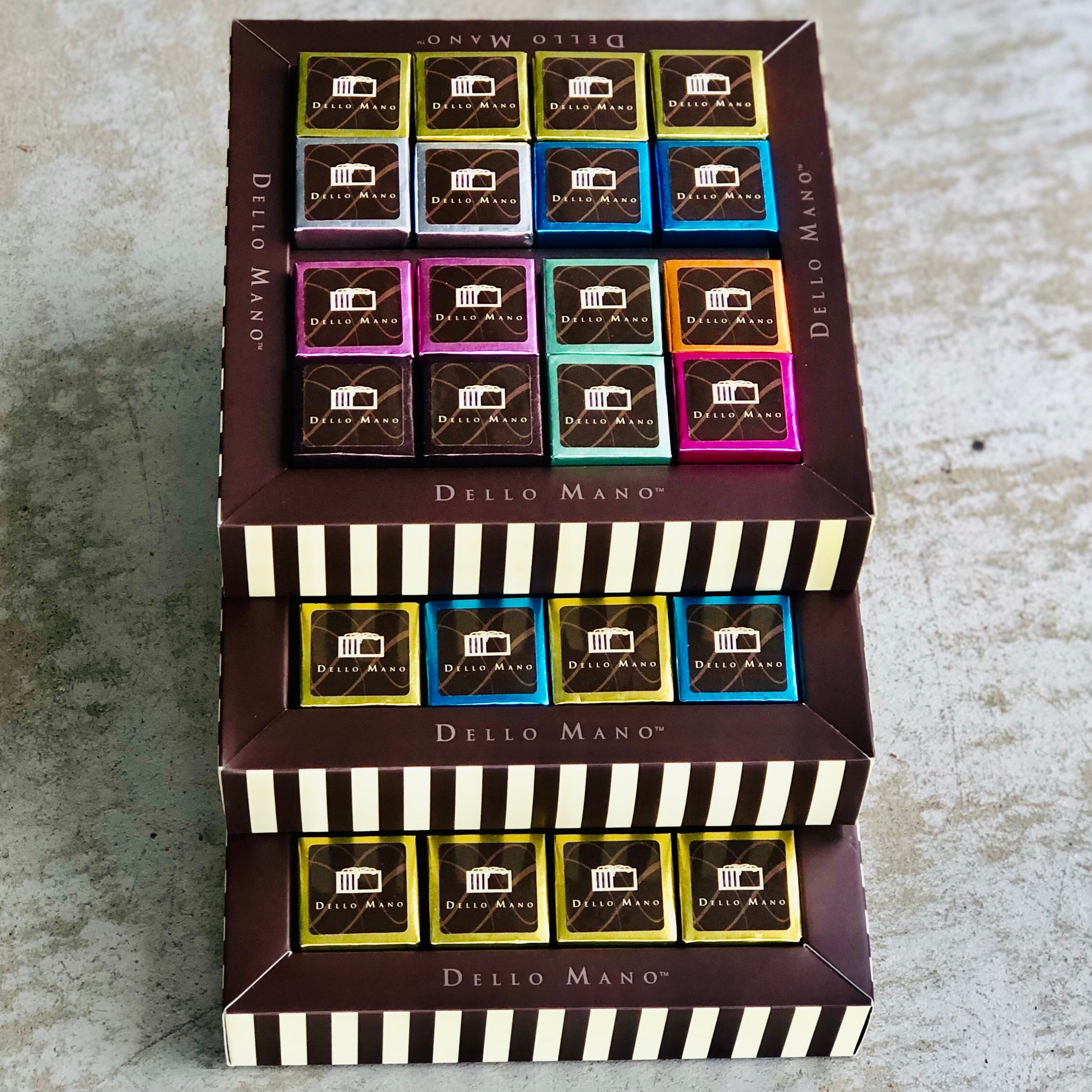 A stack of 3 brownie gift boxes with coloured brownie cubes