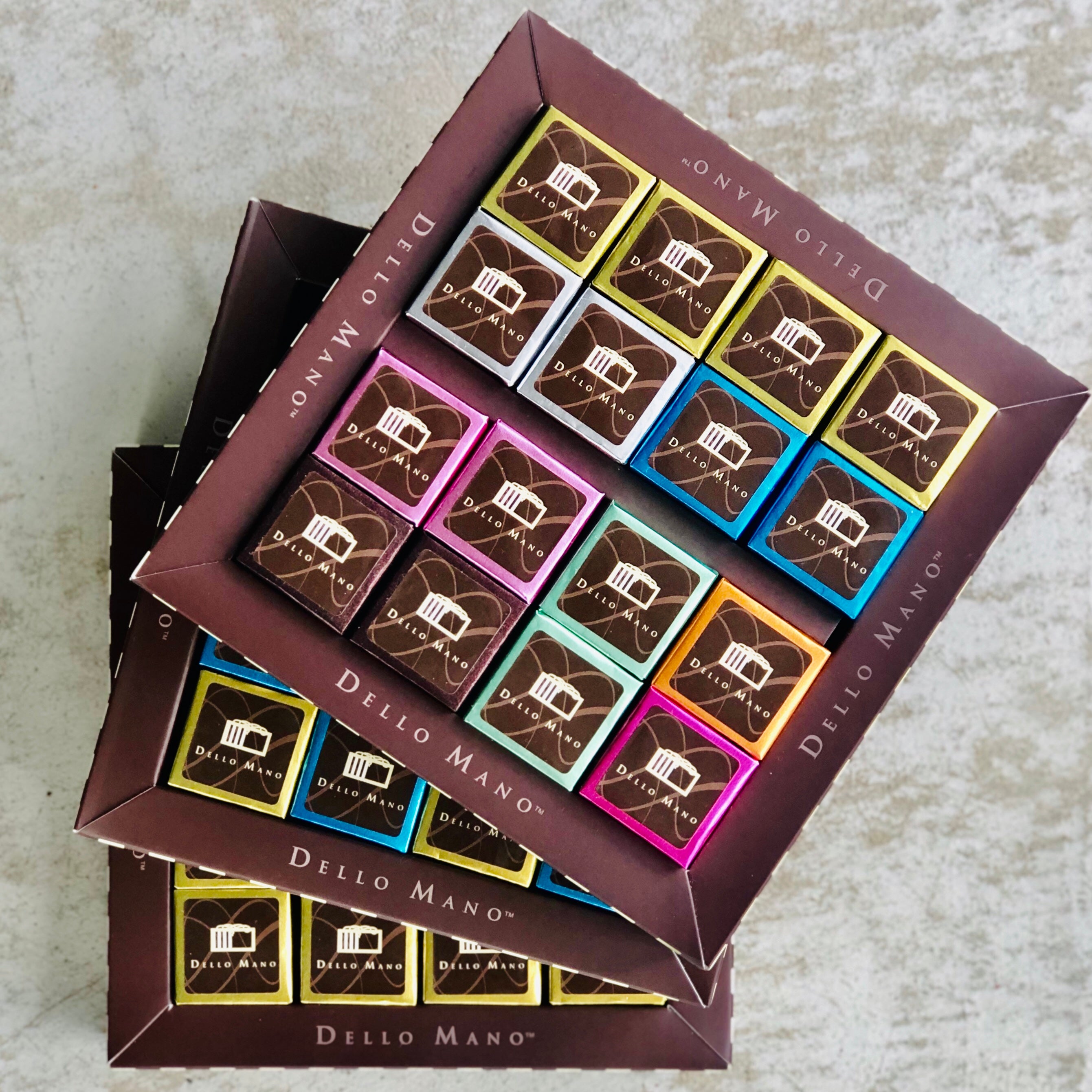 Three brownie gift boxes stacked on top of each other with label saying Dello Mano