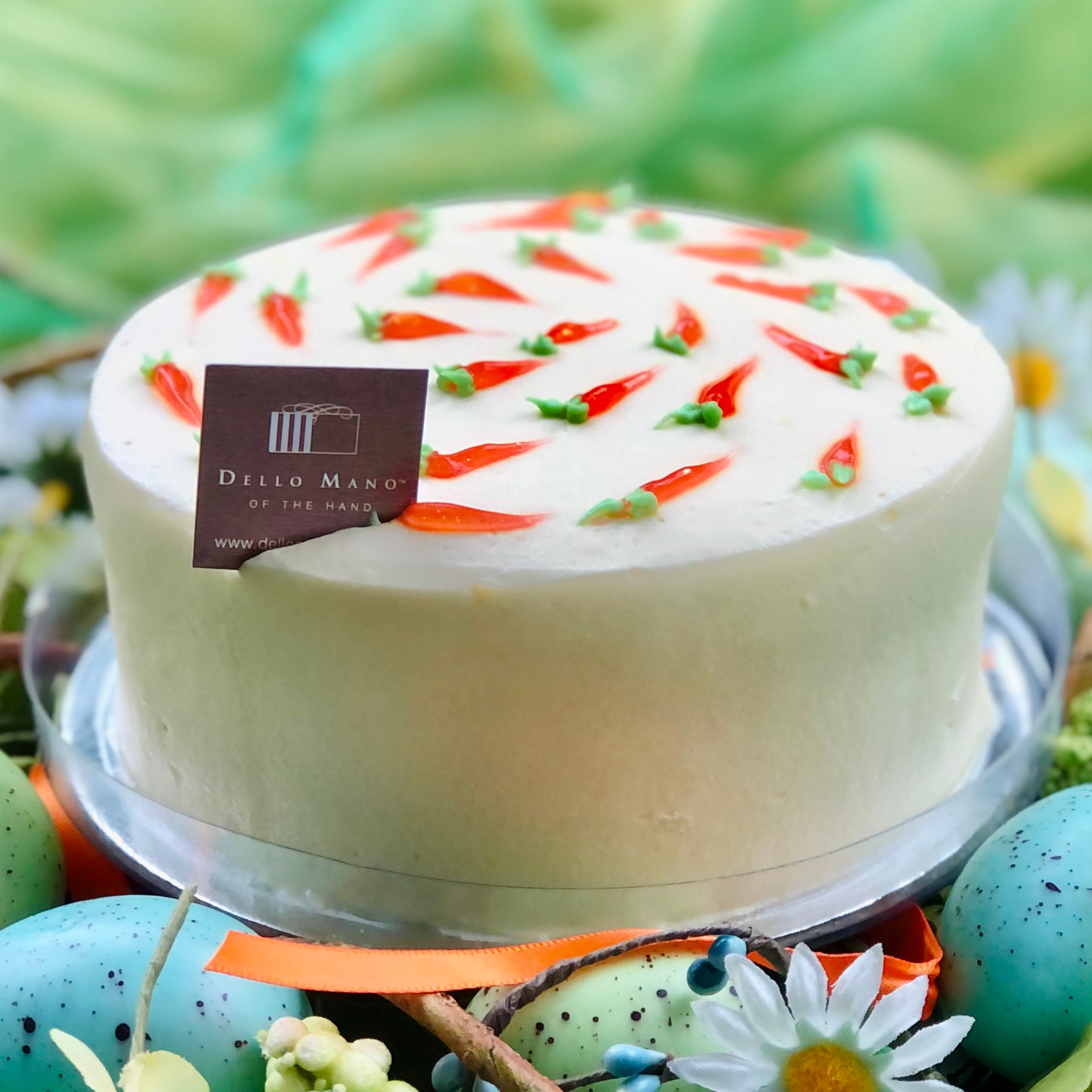 A carrot cake with tag that says Dello Mano with green background