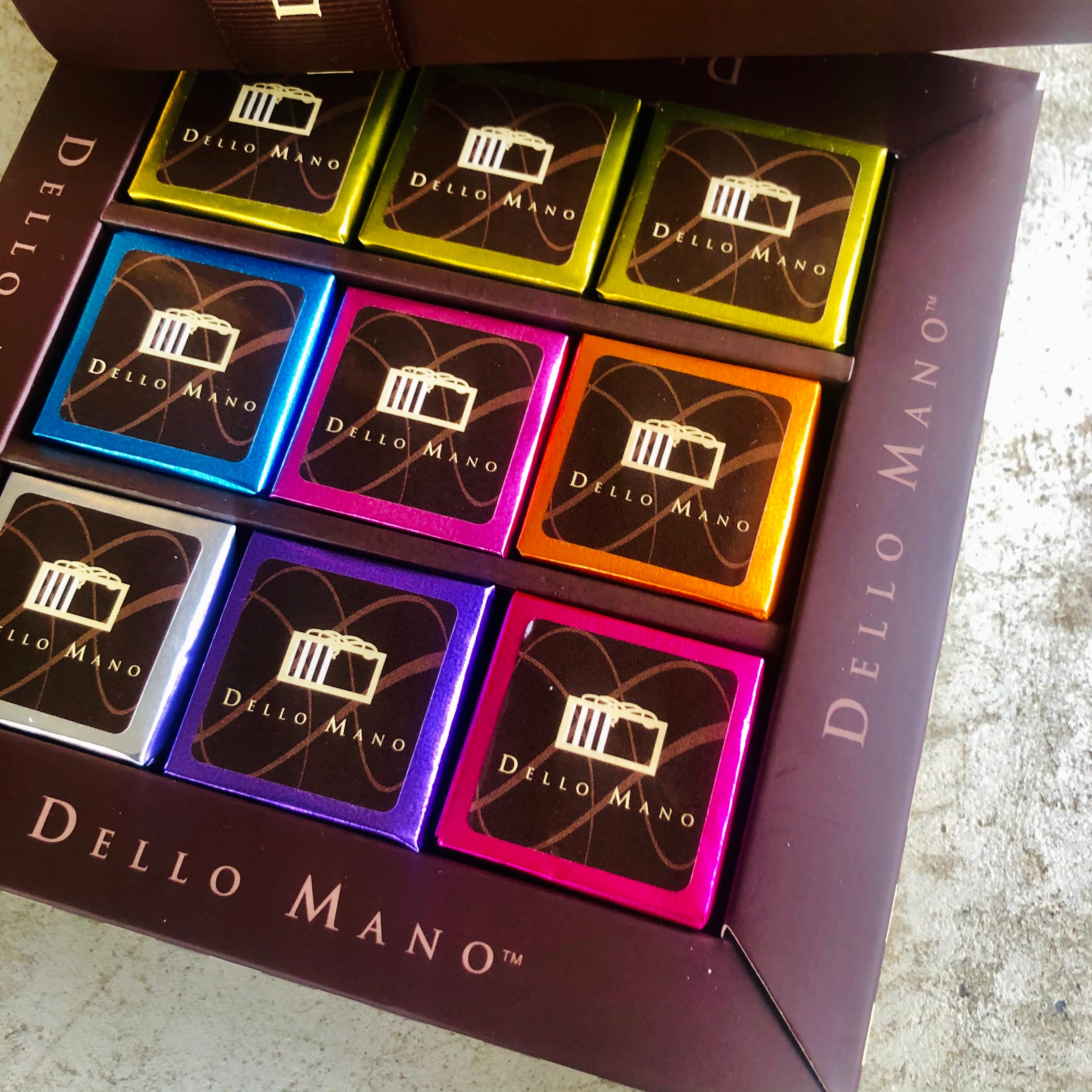 An open view of nine pieces of brownies in a chocolate gift box