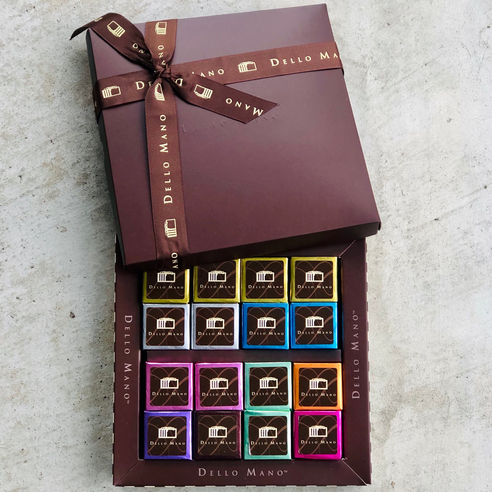 Dello Mano box of 16 gourmet brownies, individually foil wrapped in premium packaging for luxury chocolate gifting.