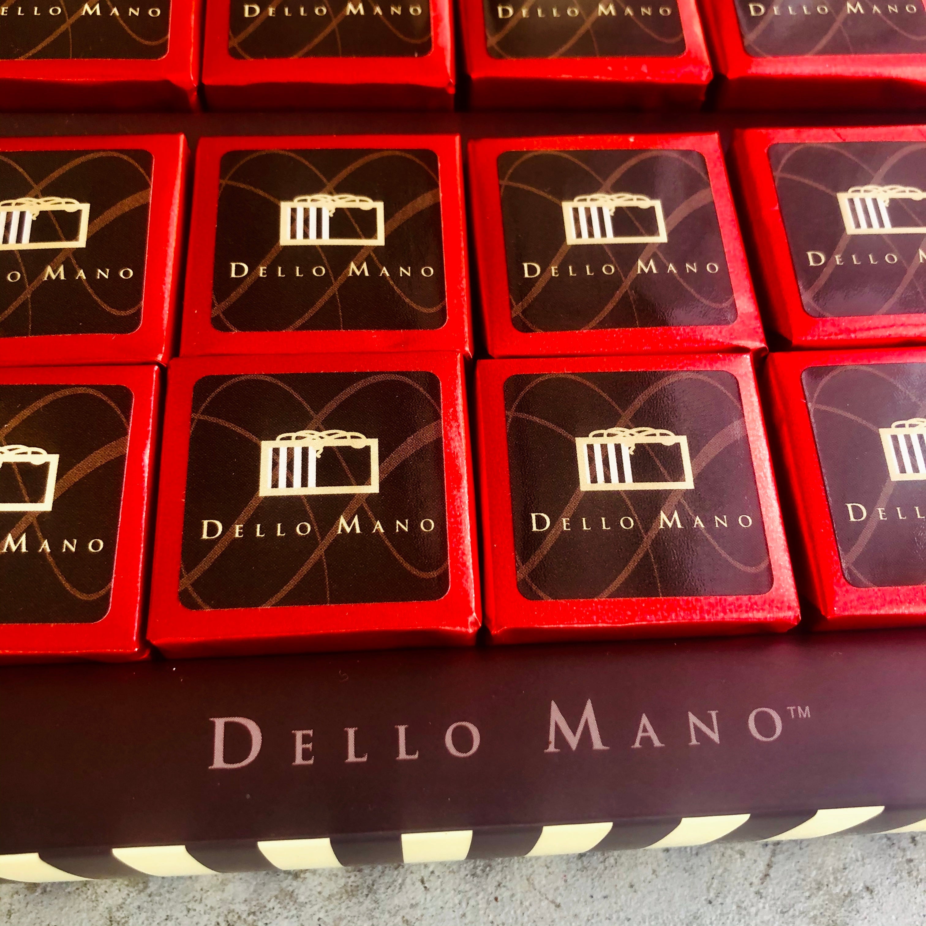 Close up of individual red foiled brownies in a Dello Mano gift box